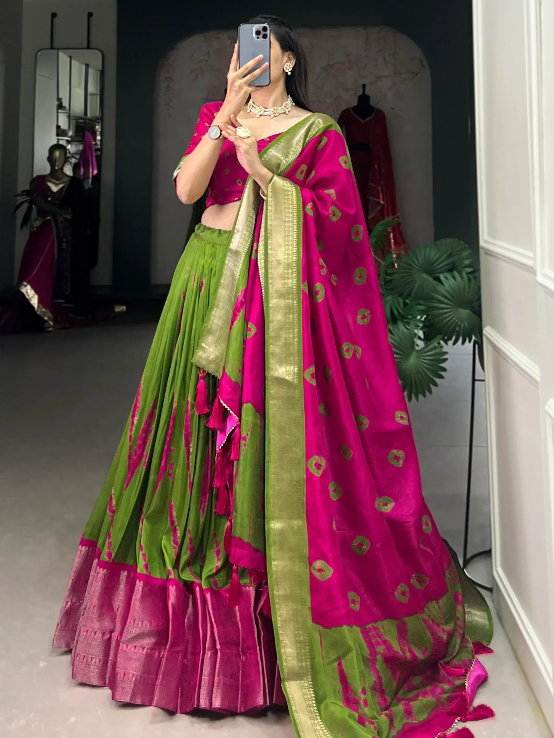Vibrant pink and green designer lehenga choli with gold border, perfect for Indian ethnic wear occasions