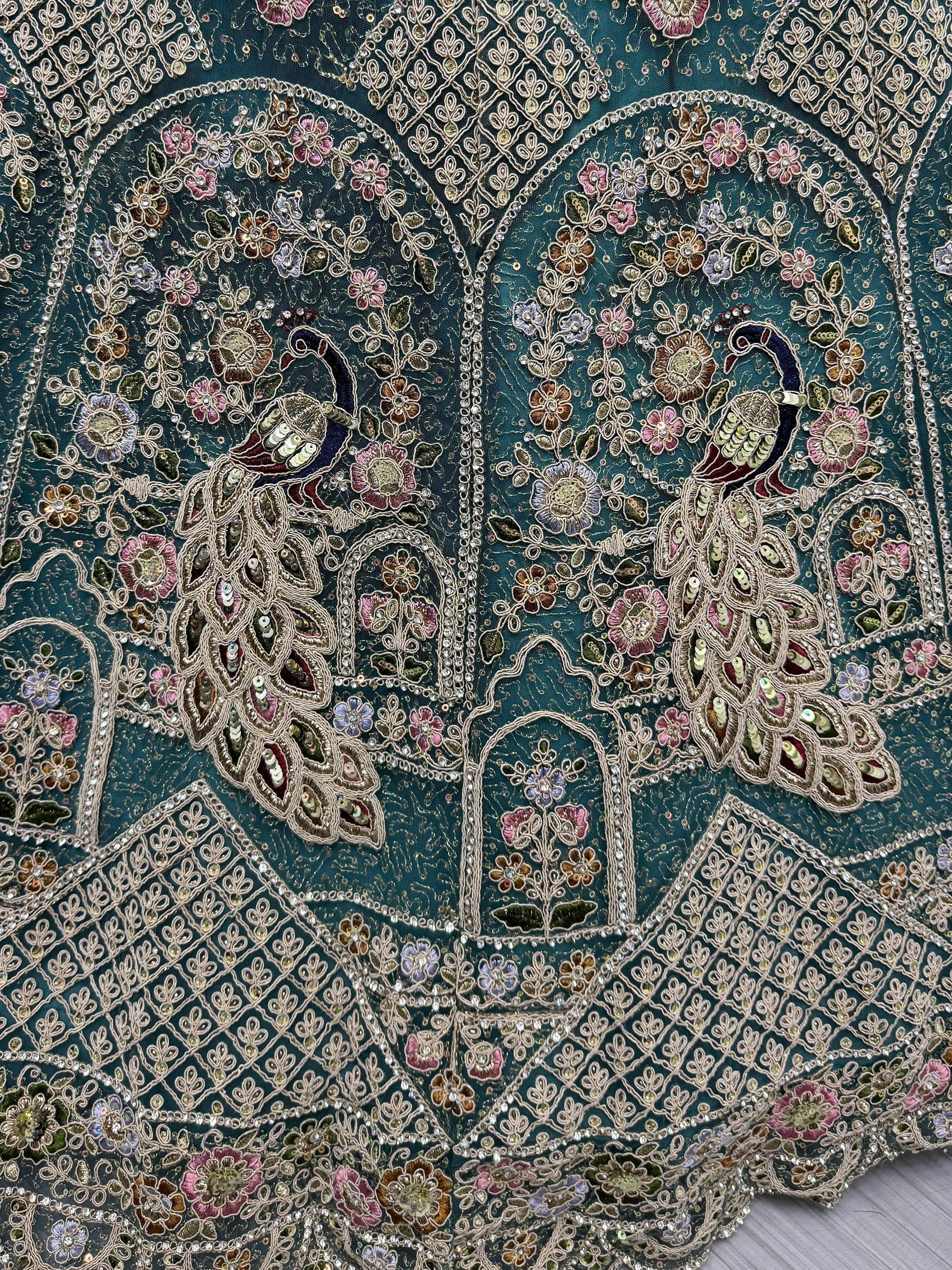 Teal ethnic blouse with peacock embroidery, floral motifs, and sequin detailing for Indian wear