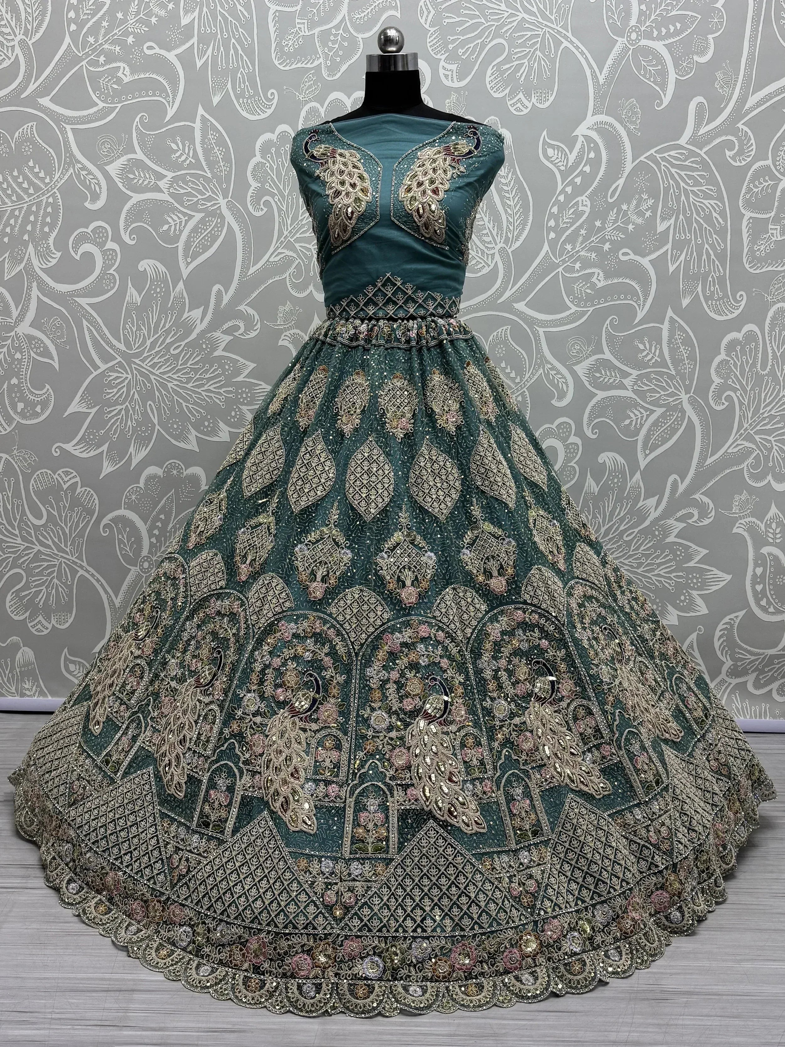 Teal designer lehenga choli with peacock embroidery and gold zari work, perfect for Indian weddings and festive occasions.