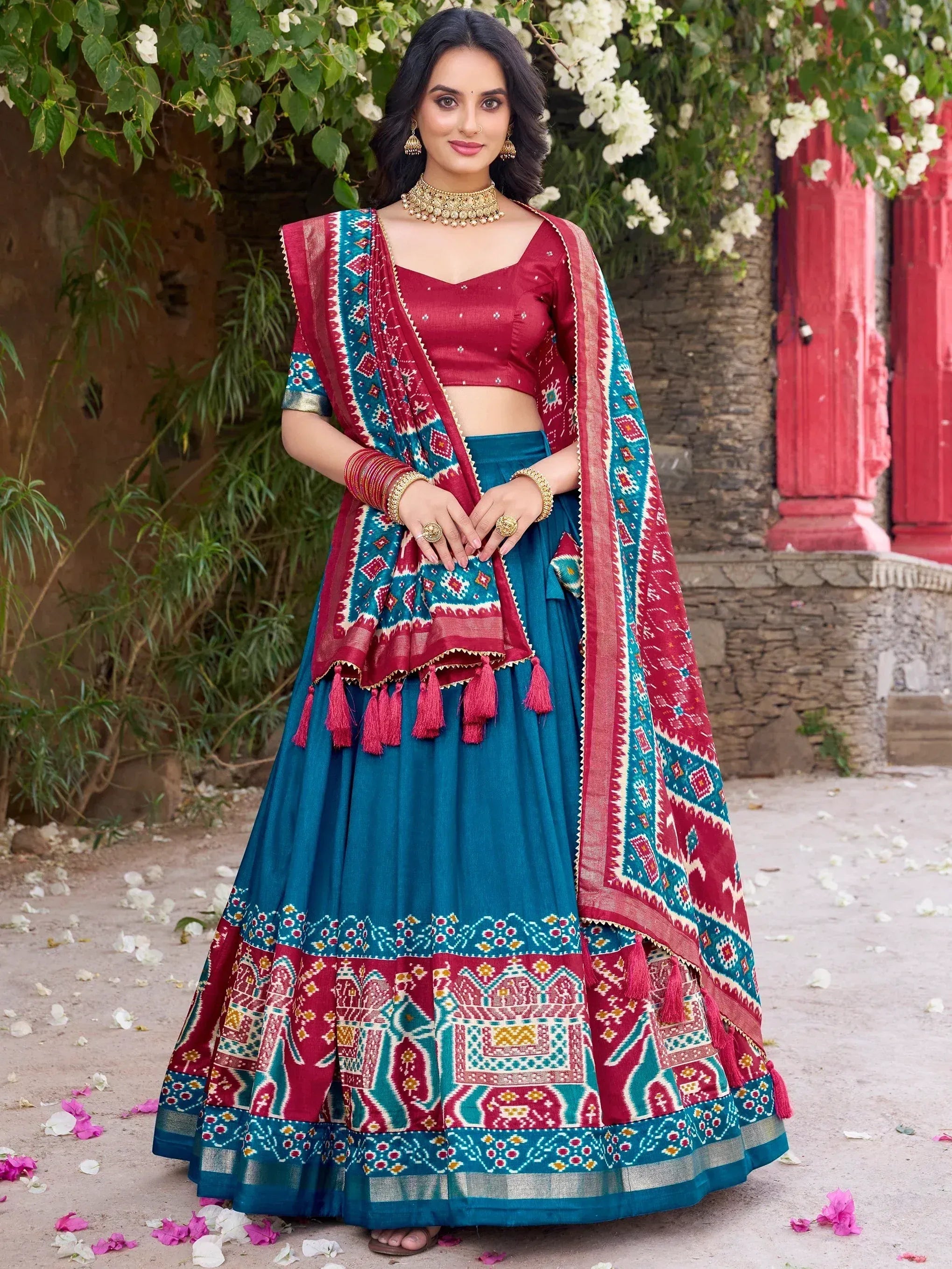 Woman in teal and maroon printed lehenga choli with dupatta, ethnic Indian wear for weddings and festivals