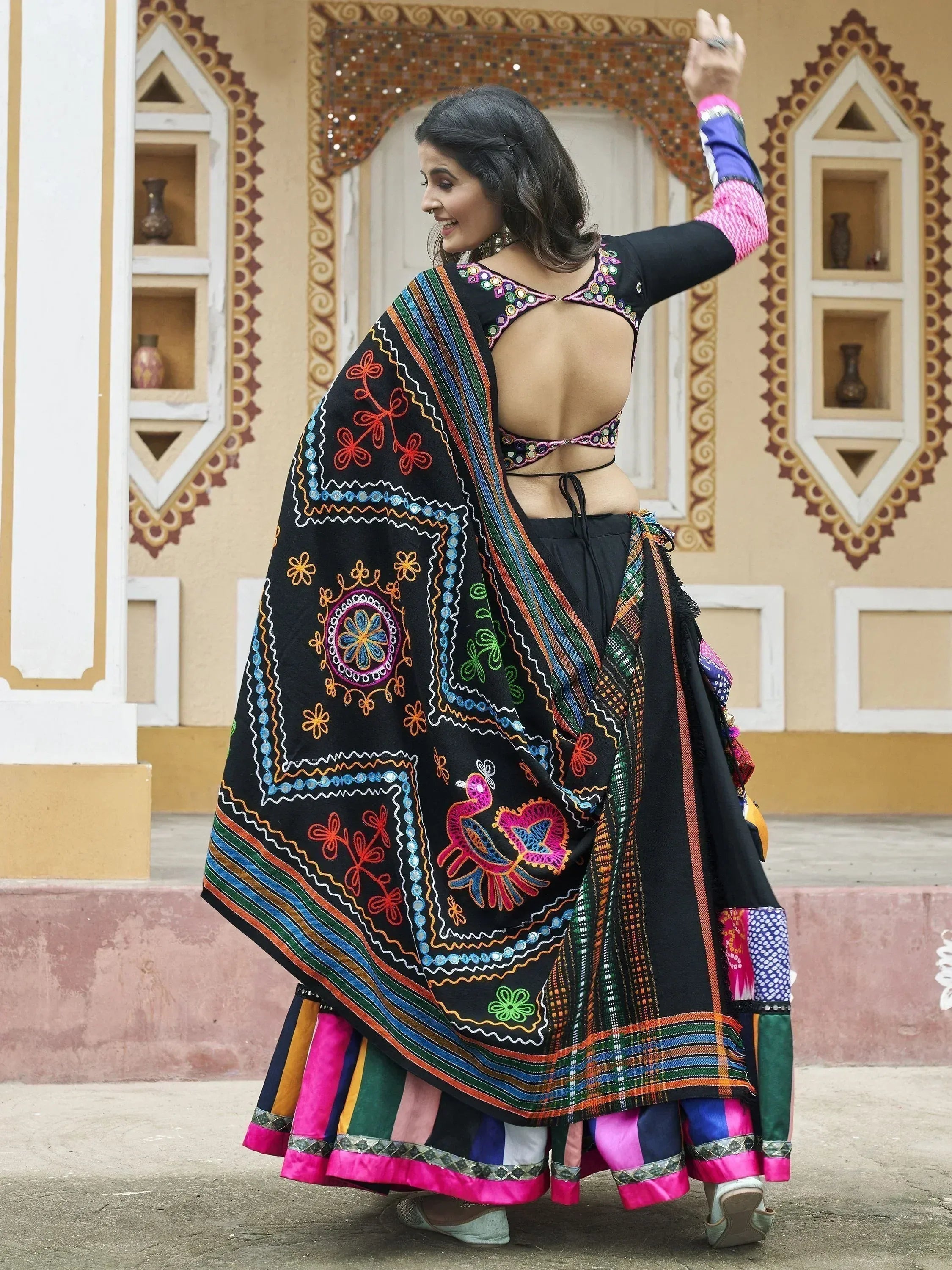 Black embroidered ethnic lehenga choli with colorful mirror work and dupatta, perfect for Indian celebrations