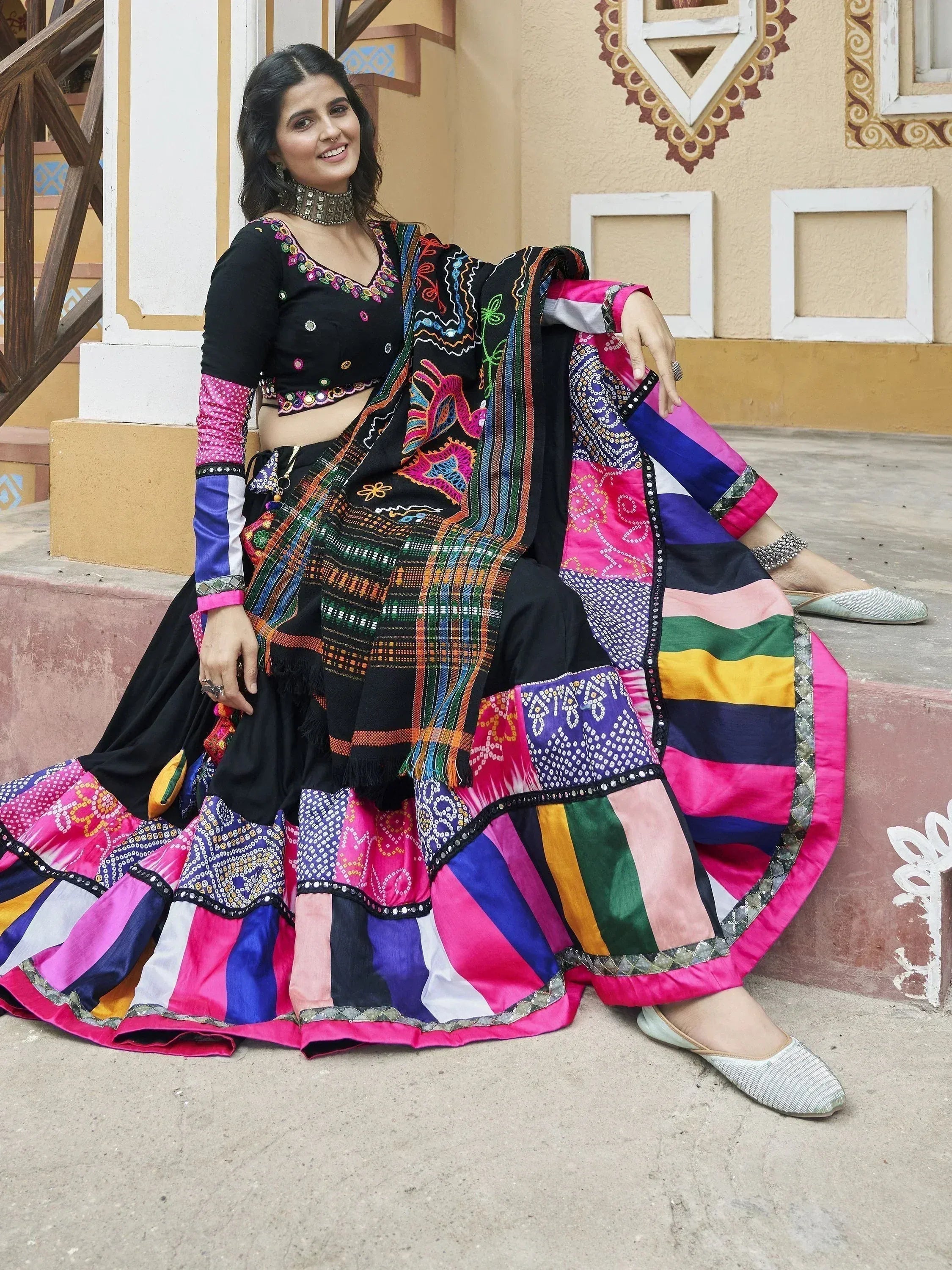 Woman in vibrant ethnic lehenga choli with colorful patchwork and embroidery, perfect for festive occasions.