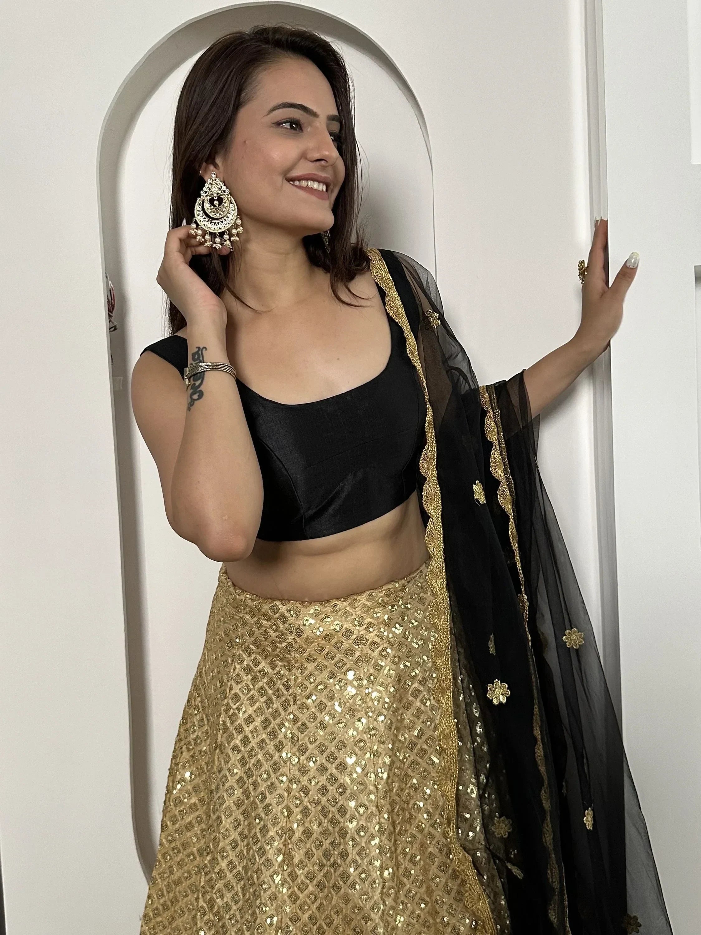 Black and gold lehenga choli with sequin skirt and sheer dupatta, perfect for Indian ethnic wear