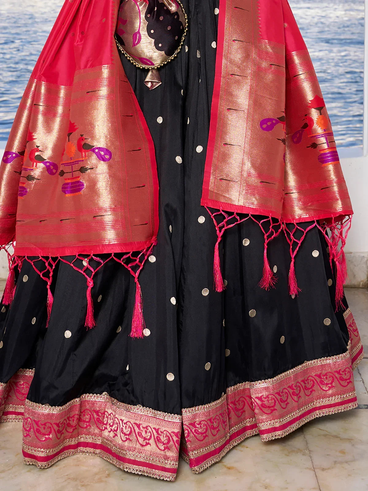 Black and pink ethnic lehenga with embroidered dupatta and tassels, perfect for Indian weddings or festivals.