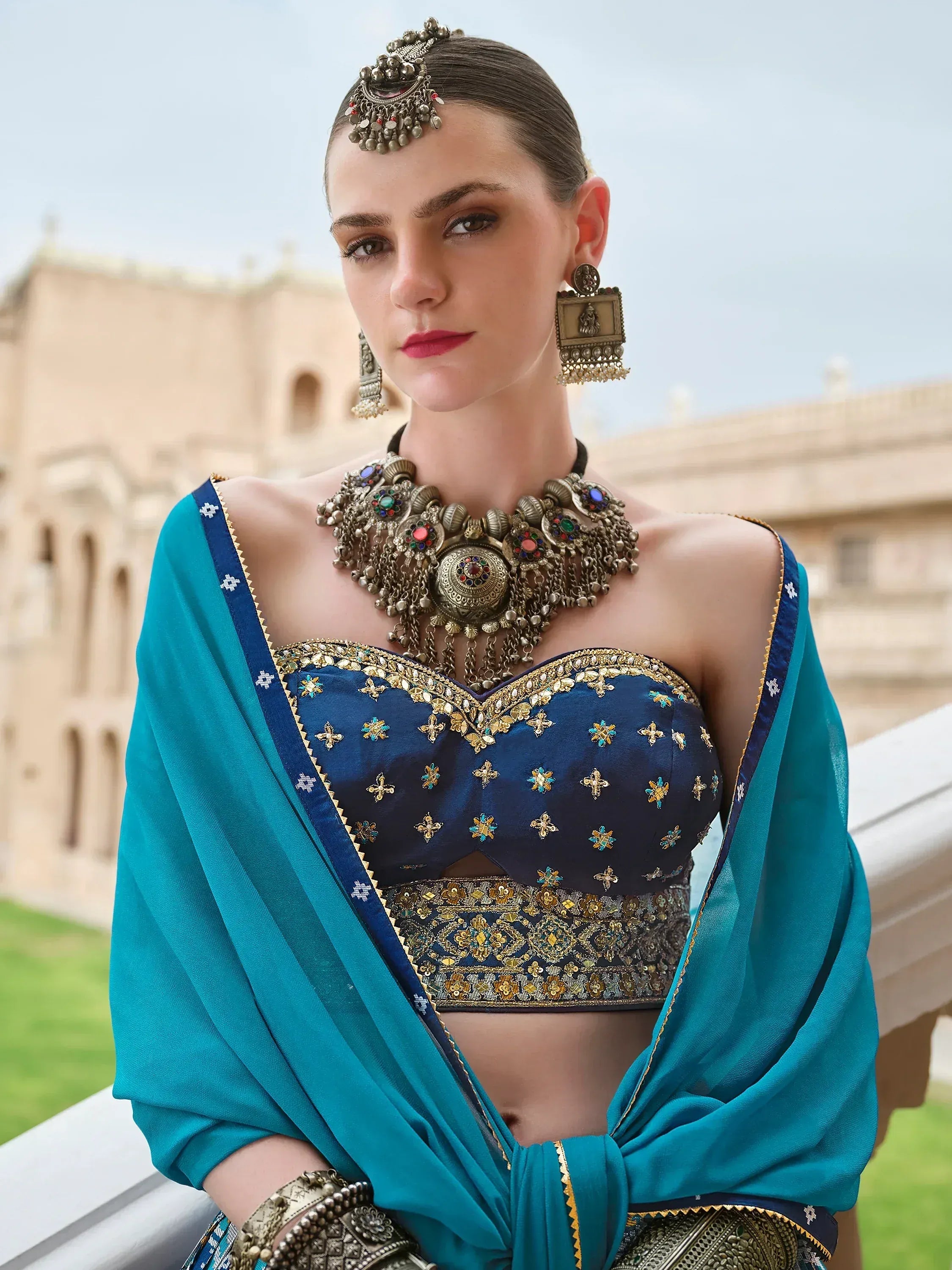 Blue embroidered lehenga choli with teal dupatta, traditional Indian ethnic wear, ornate jewelry