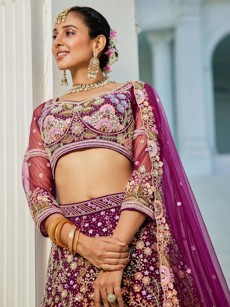 Elegant purple embroidered lehenga choli with floral motifs and sheer sleeves, perfect for Indian weddings and festive occasions.