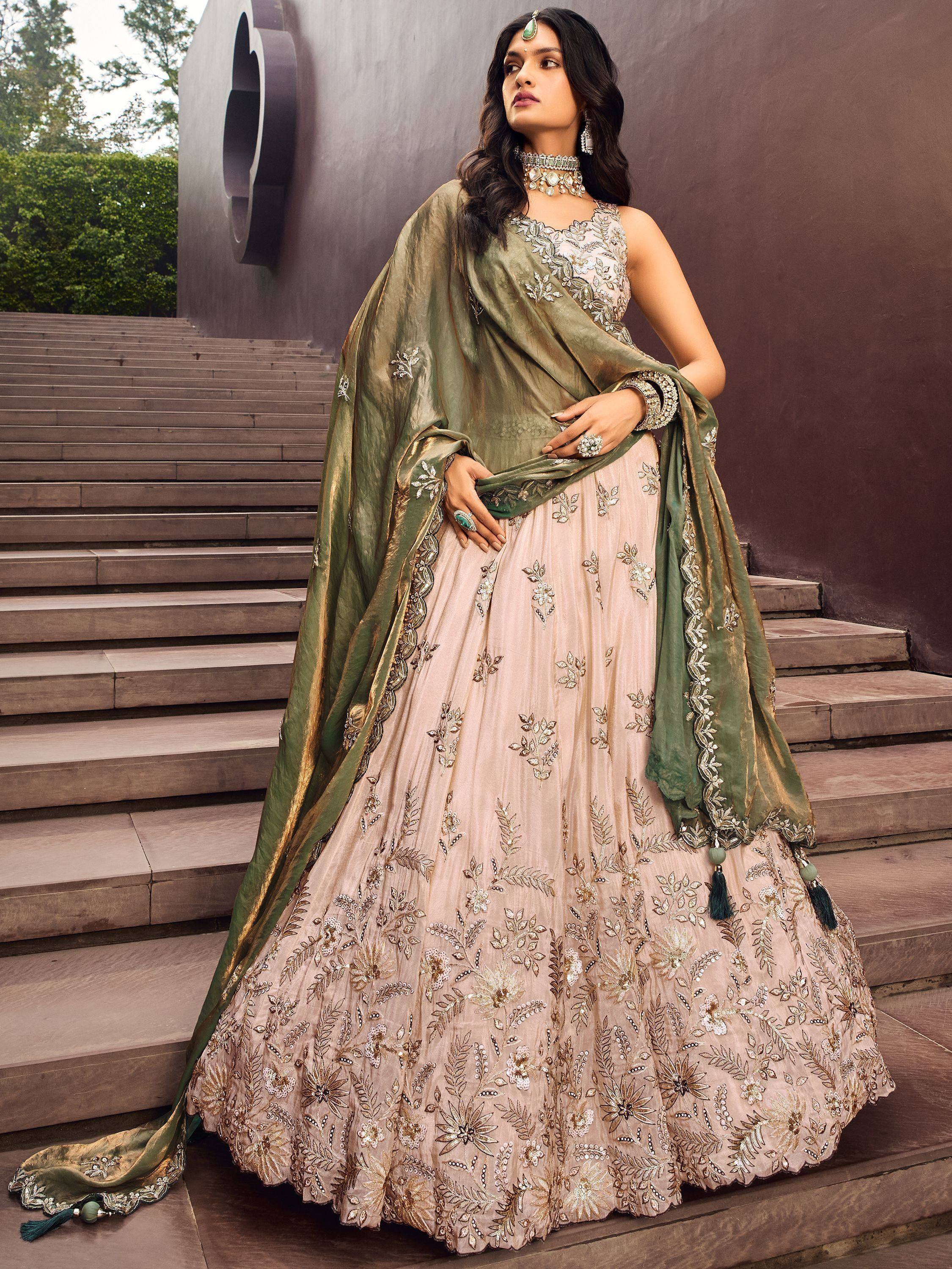 Elegant blush pink lehenga choli with gold floral embroidery and olive green dupatta, perfect for Indian weddings.