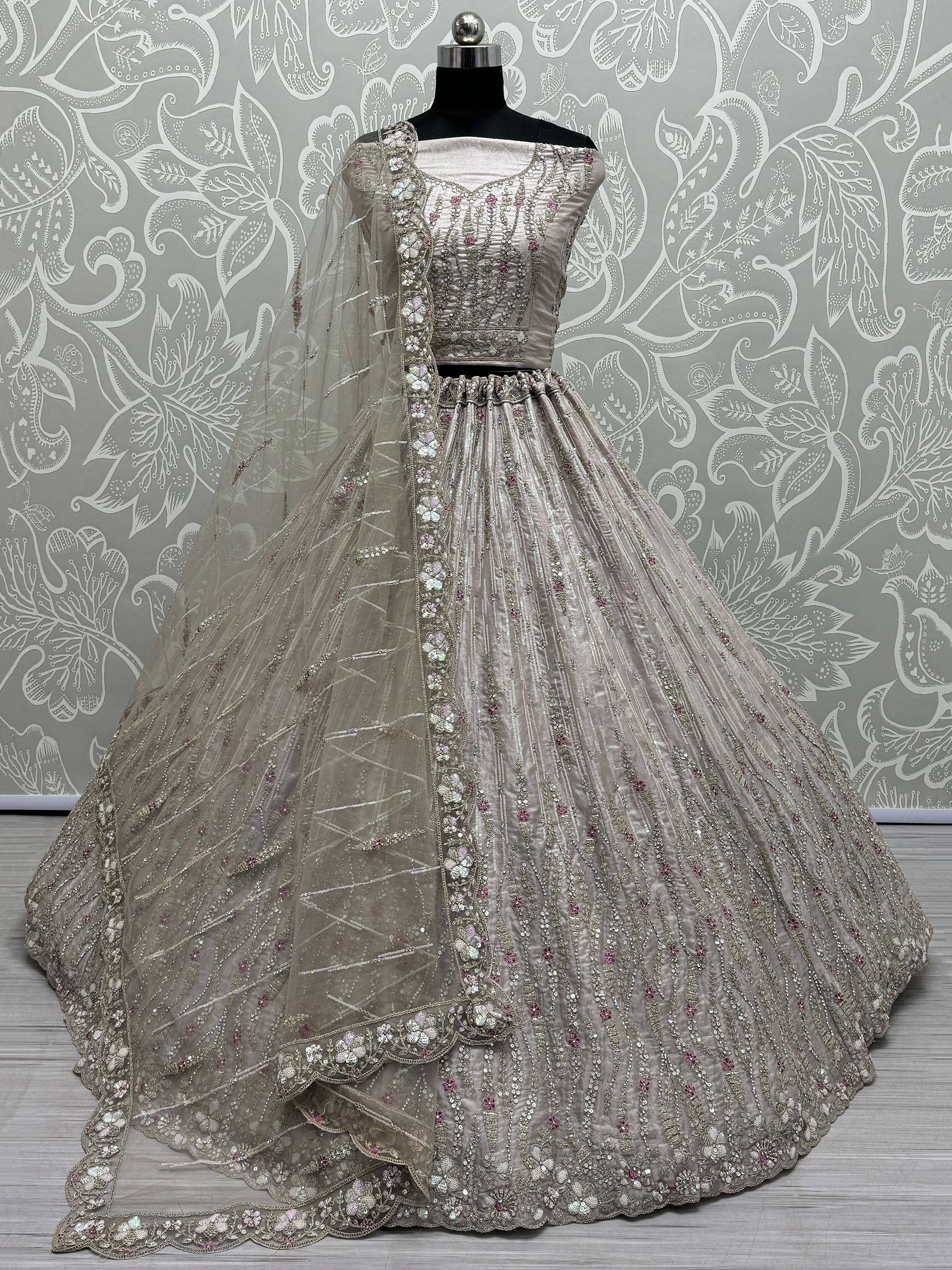 Elegant silver lehenga choli with intricate floral embroidery and sequin work, perfect for weddings and festive occasions.