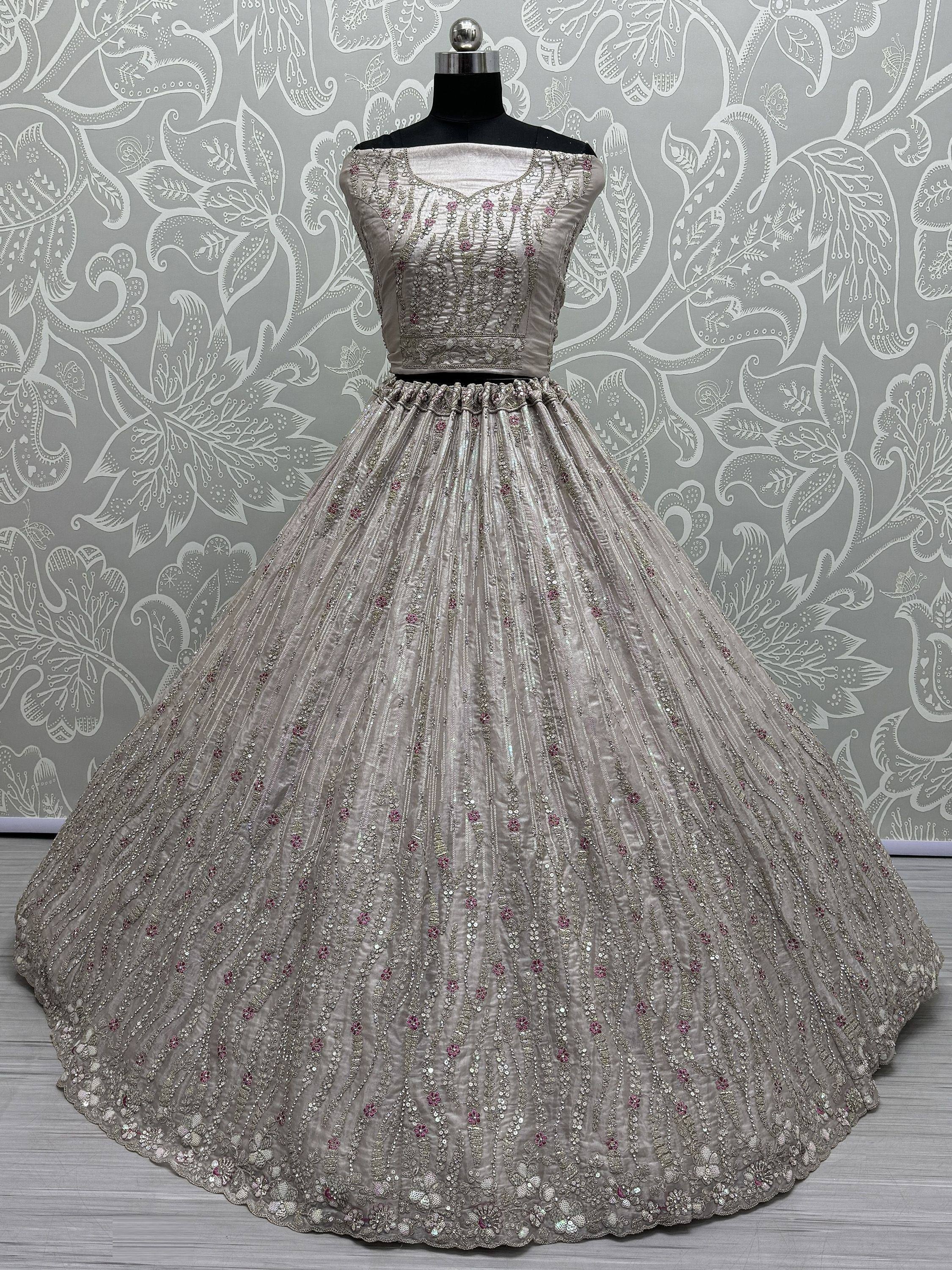 Elegant silver designer lehenga choli with intricate embroidery and sequins, perfect for weddings and festive occasions.