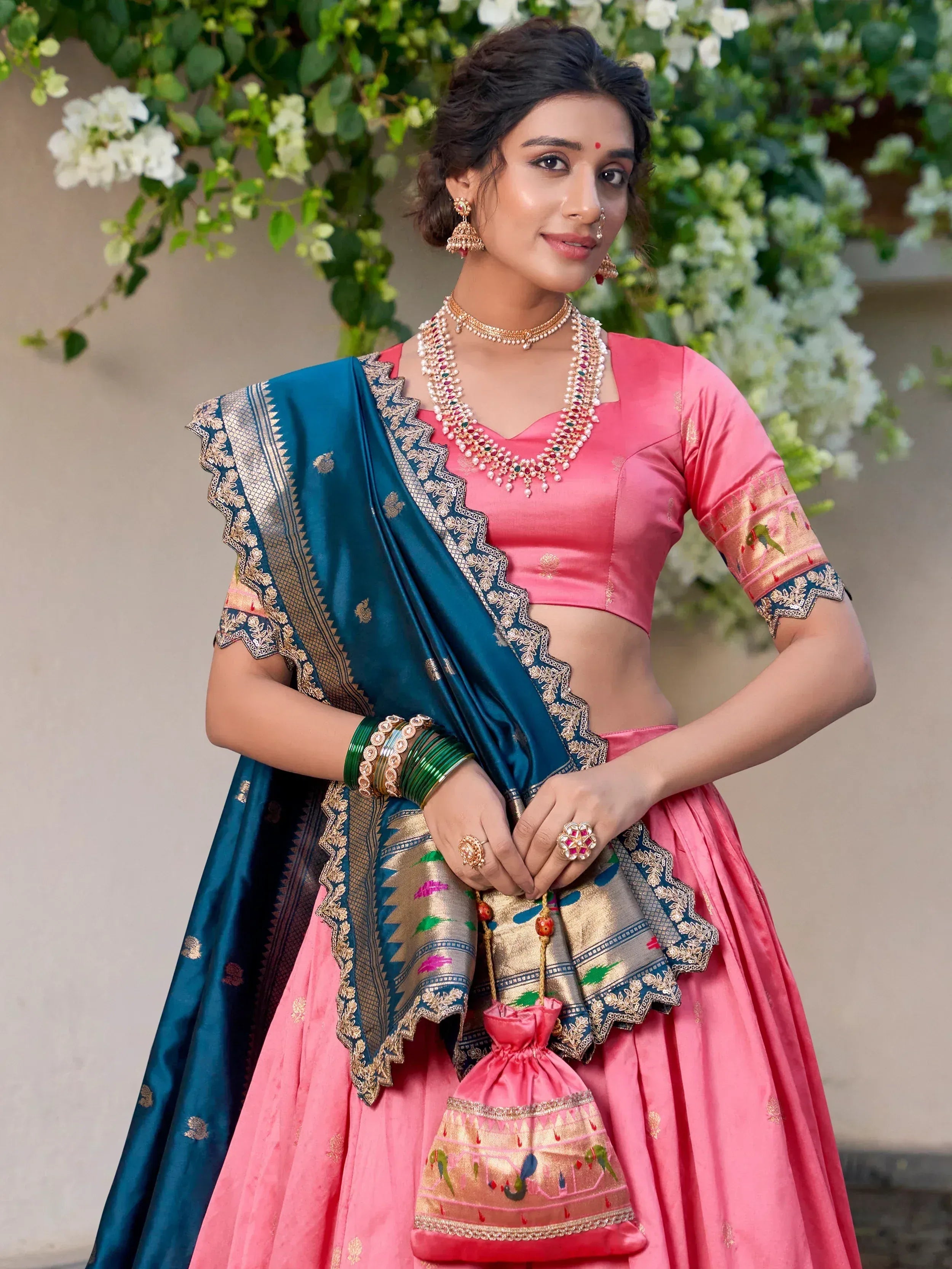 Pink and teal designer lehenga choli with gold embroidery, perfect for Indian weddings and festive occasions.