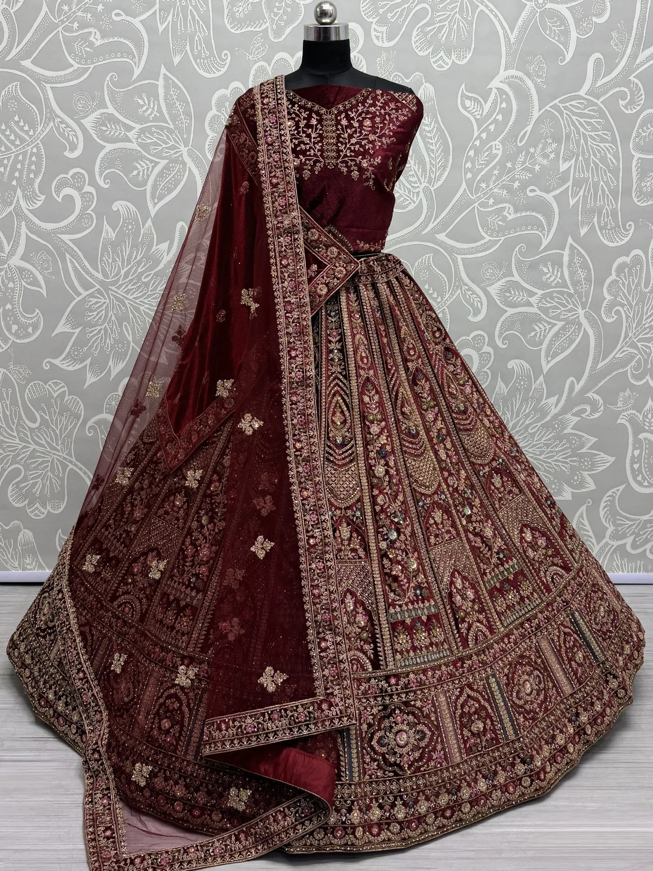 Maroon velvet designer lehenga choli with heavy gold embroidery and net dupatta for Indian weddings