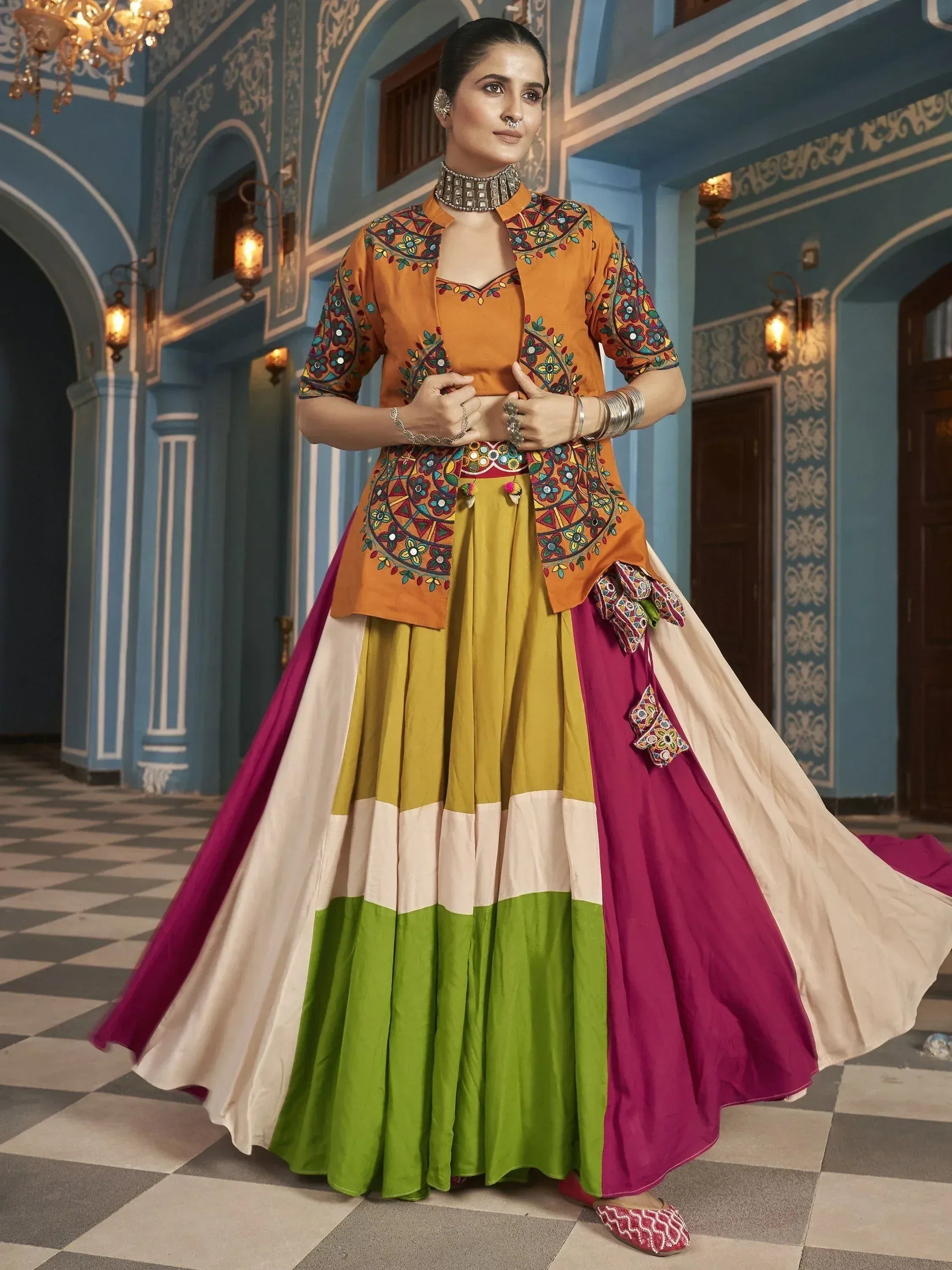 Woman in vibrant Indian ethnic wear with embroidered orange top and multicolor lehenga skirt