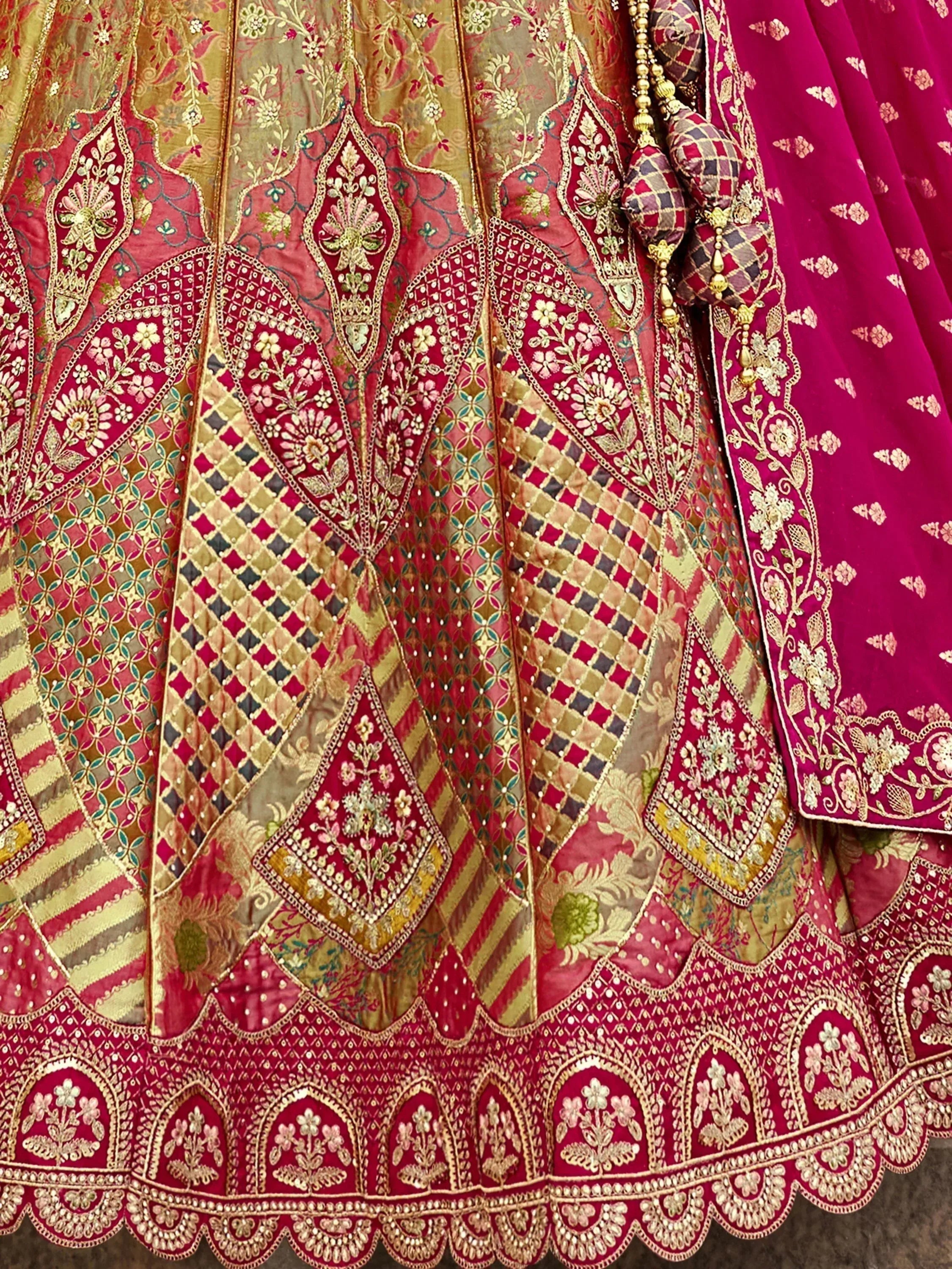 Luxury Indian lehenga choli with intricate gold embroidery, floral motifs, and patchwork design in red and gold tones
