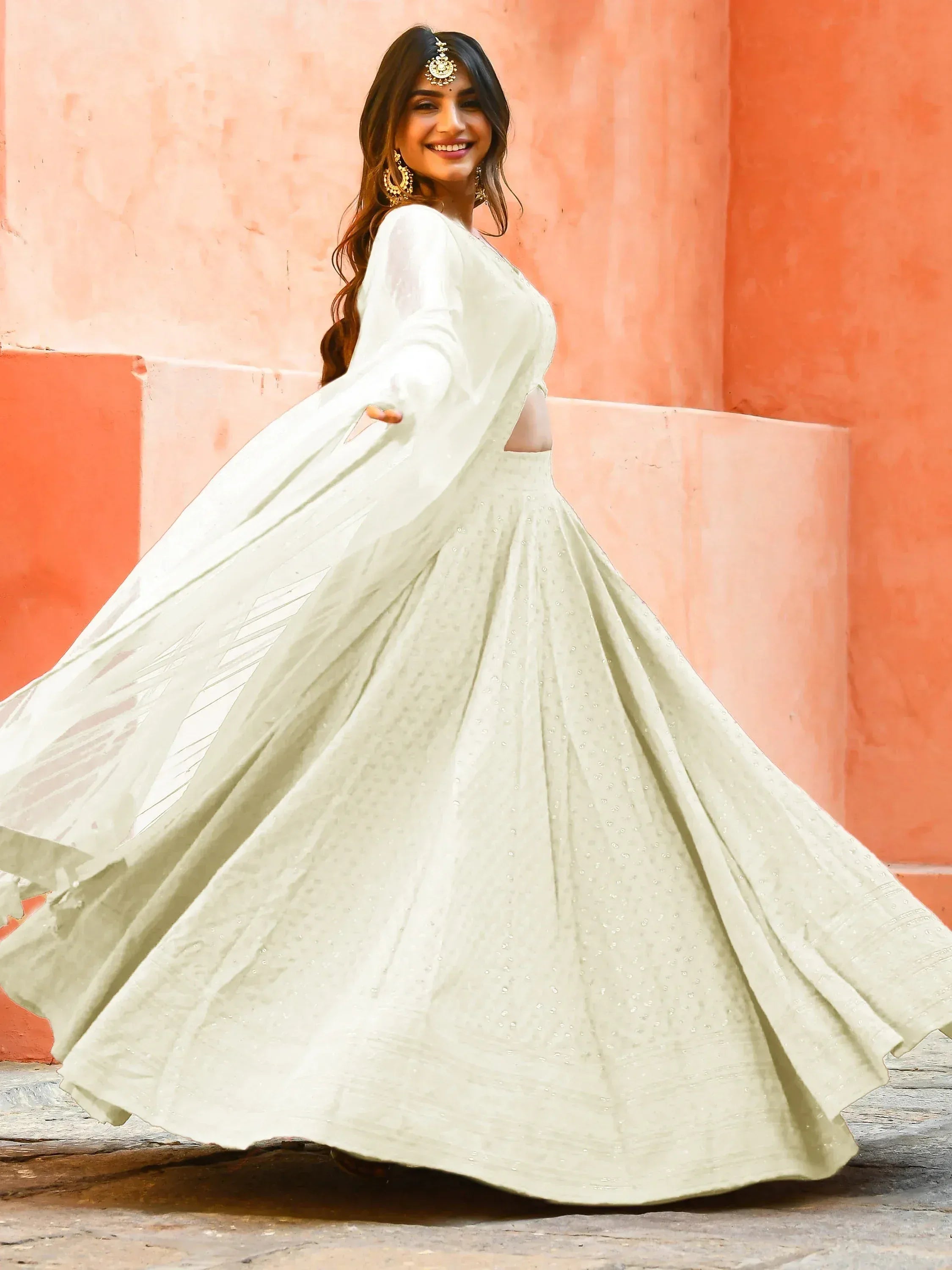 Elegant white lehenga choli with sheer sleeves and embellished skirt, perfect for Indian ethnic occasions