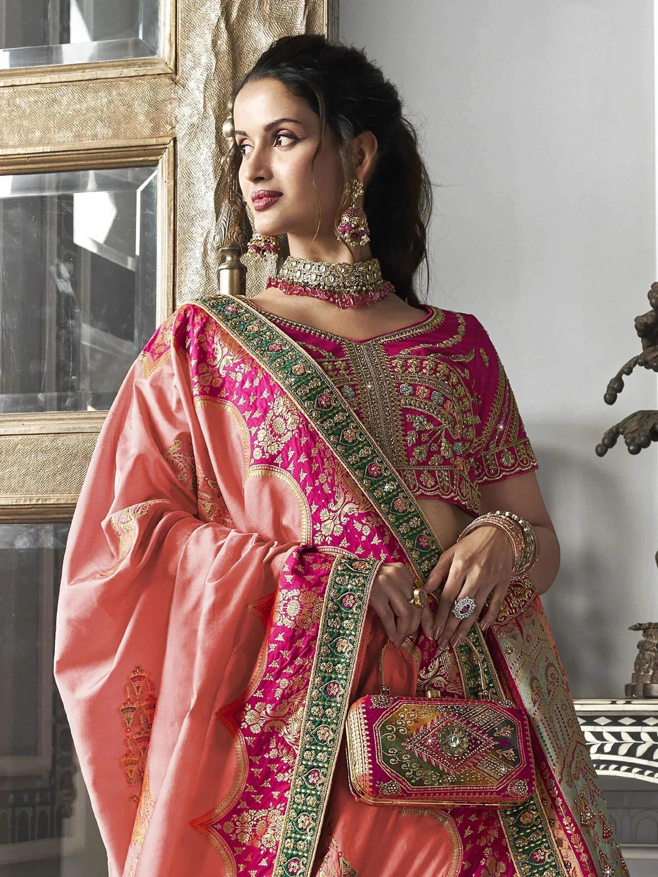 Elegant pink and coral Indian lehenga choli with gold embroidery, perfect for weddings and festive occasions.