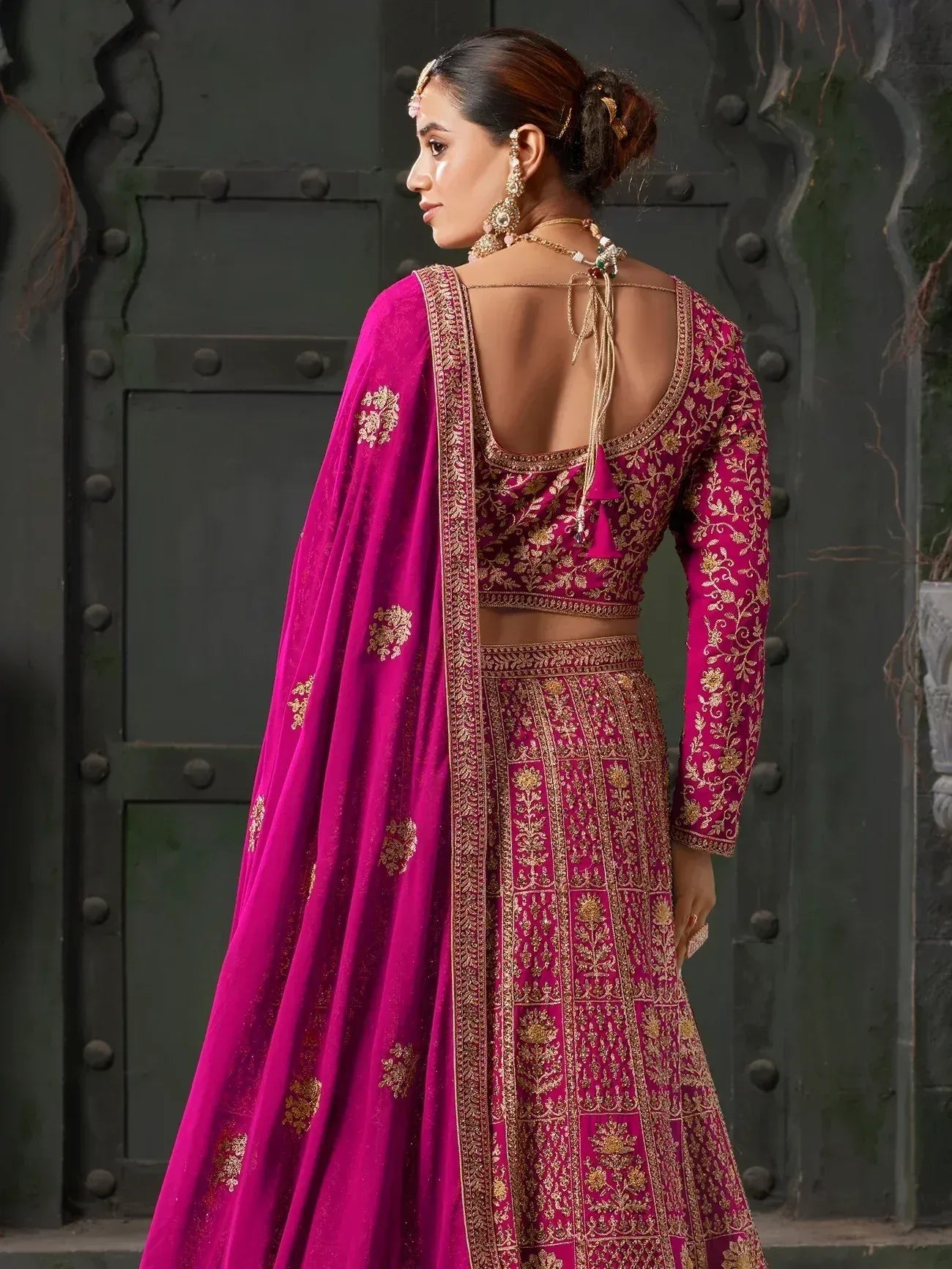 Fuchsia pink embroidered lehenga choli with gold detailing, back view, ethnic Indian wear