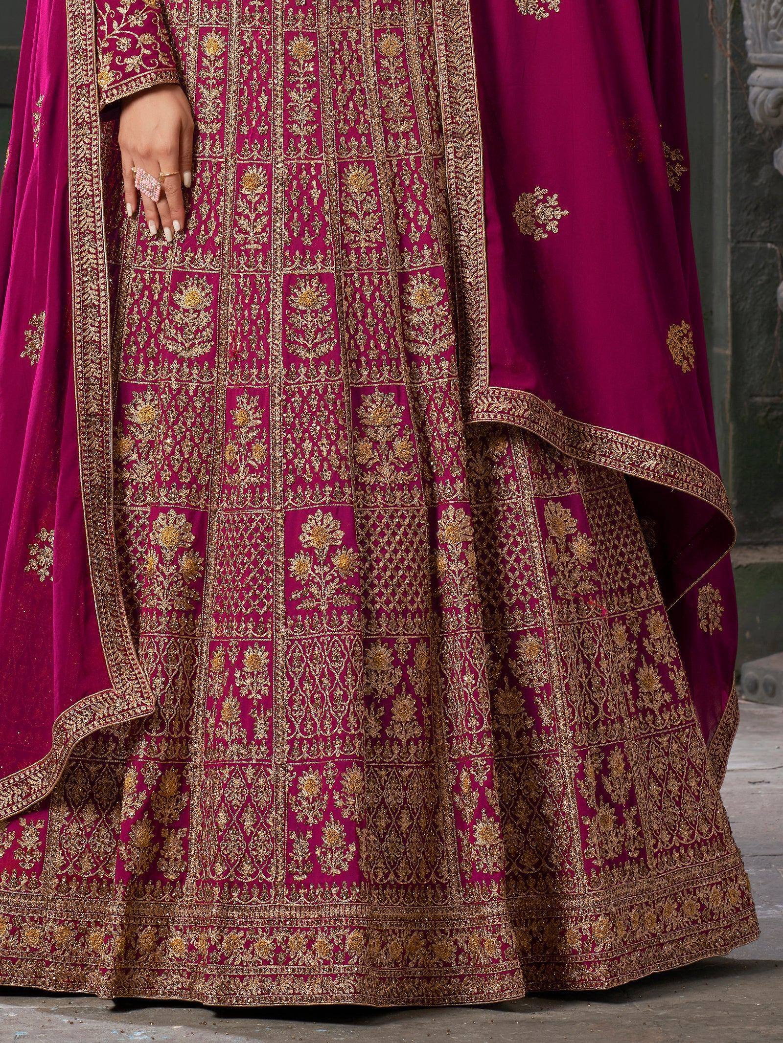Rich magenta lehenga choli with intricate gold embroidery, perfect for Indian weddings and festive occasions.