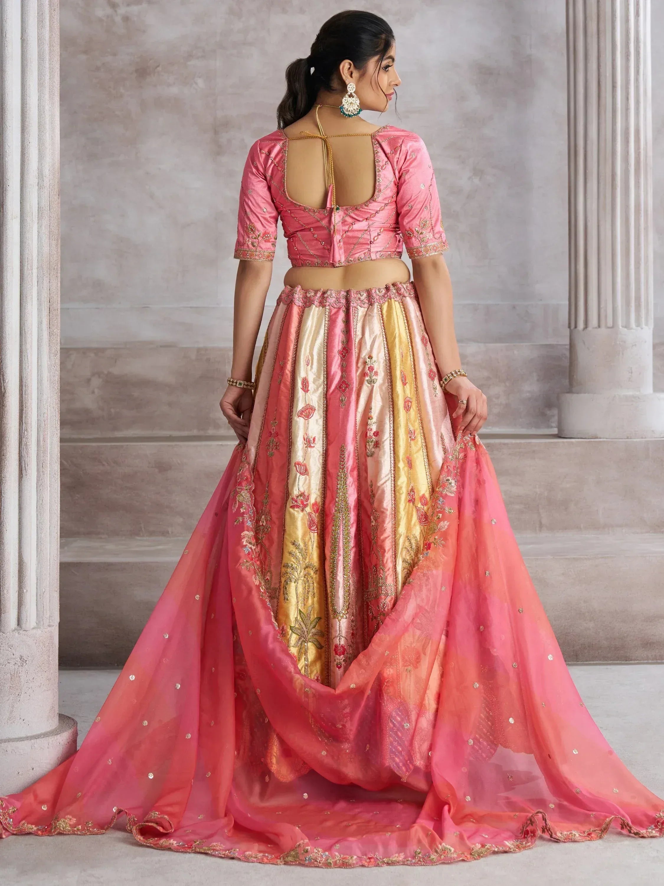 Pink and gold embroidered lehenga choli with open back blouse, perfect for Indian weddings and festive occasions