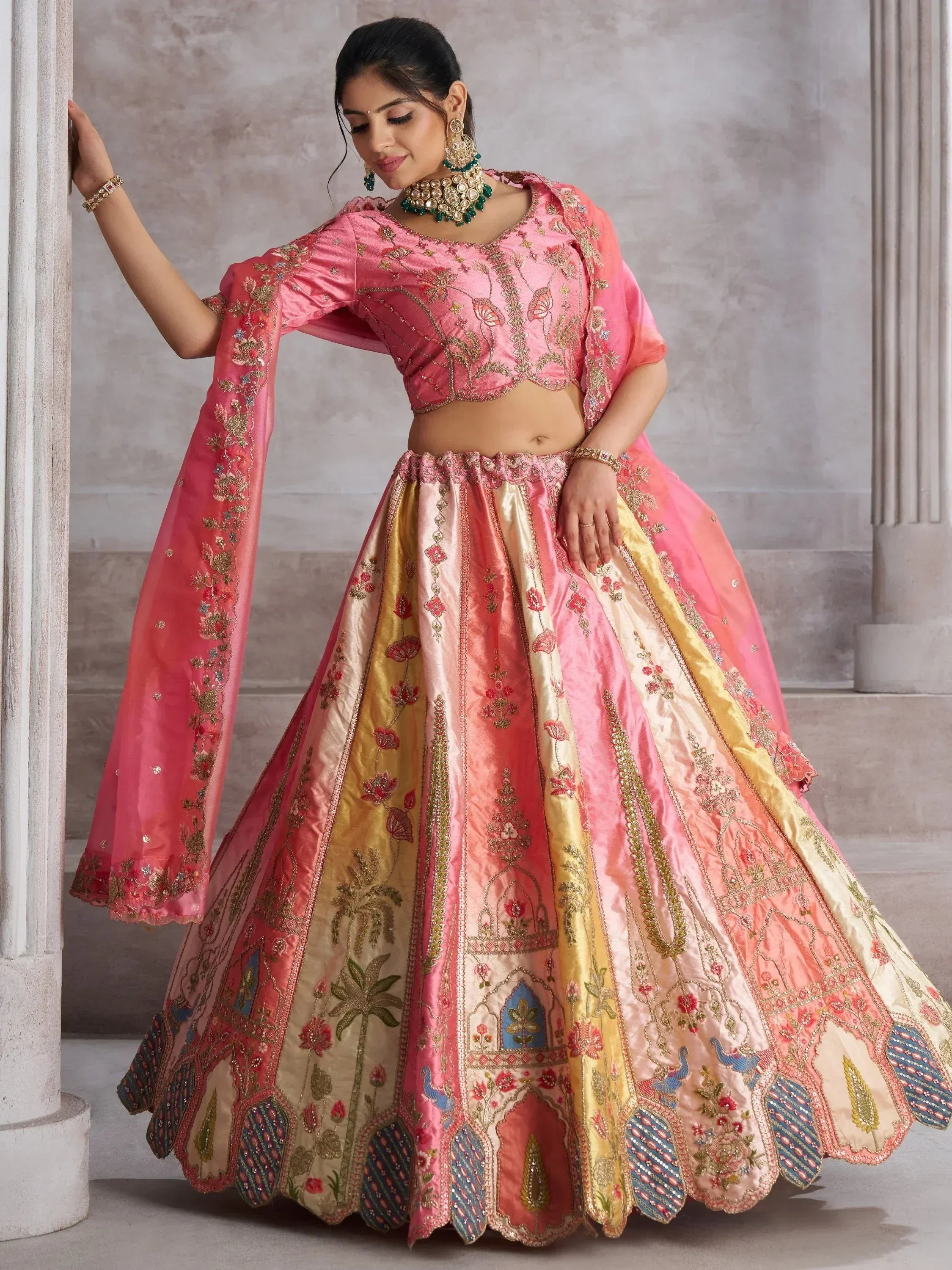 Pink and gold embroidered lehenga choli with floral and peacock motifs, perfect for Indian weddings and festive occasions.
