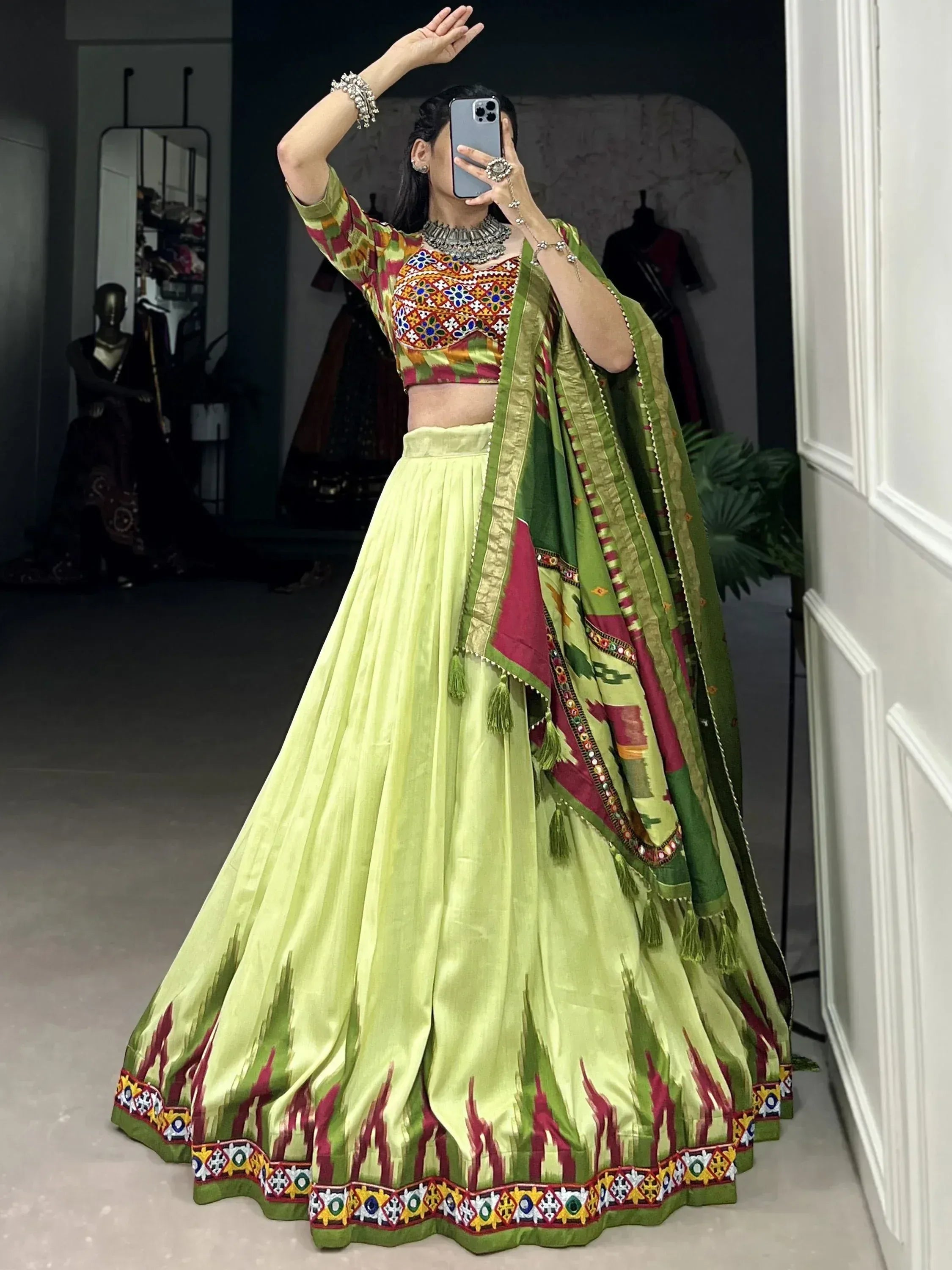 Woman in vibrant green lehenga choli with embroidered blouse and dupatta, perfect for Indian ethnic occasions.