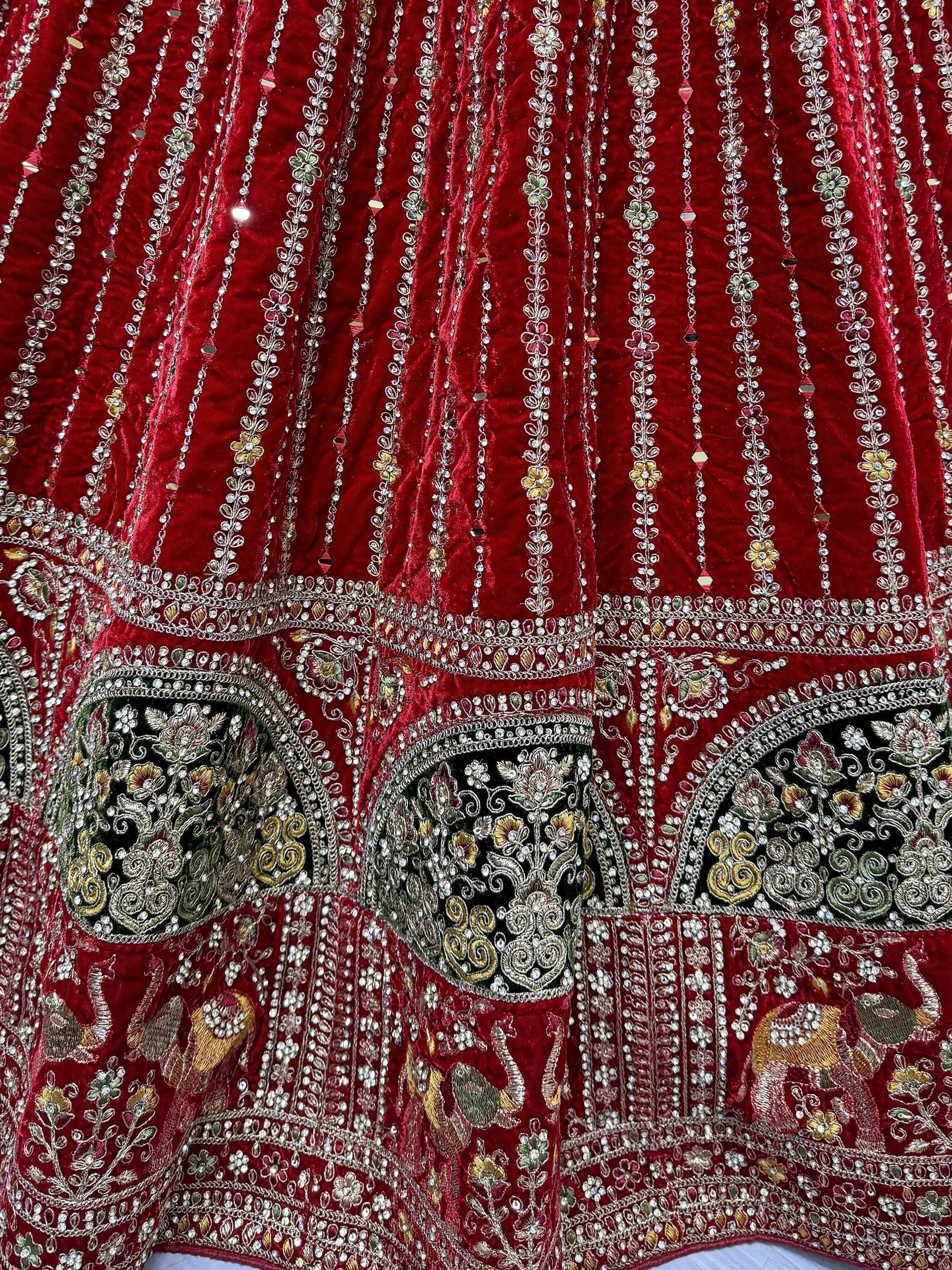 Red velvet lehenga with intricate floral and elephant embroidery, perfect for Indian ethnic wear.