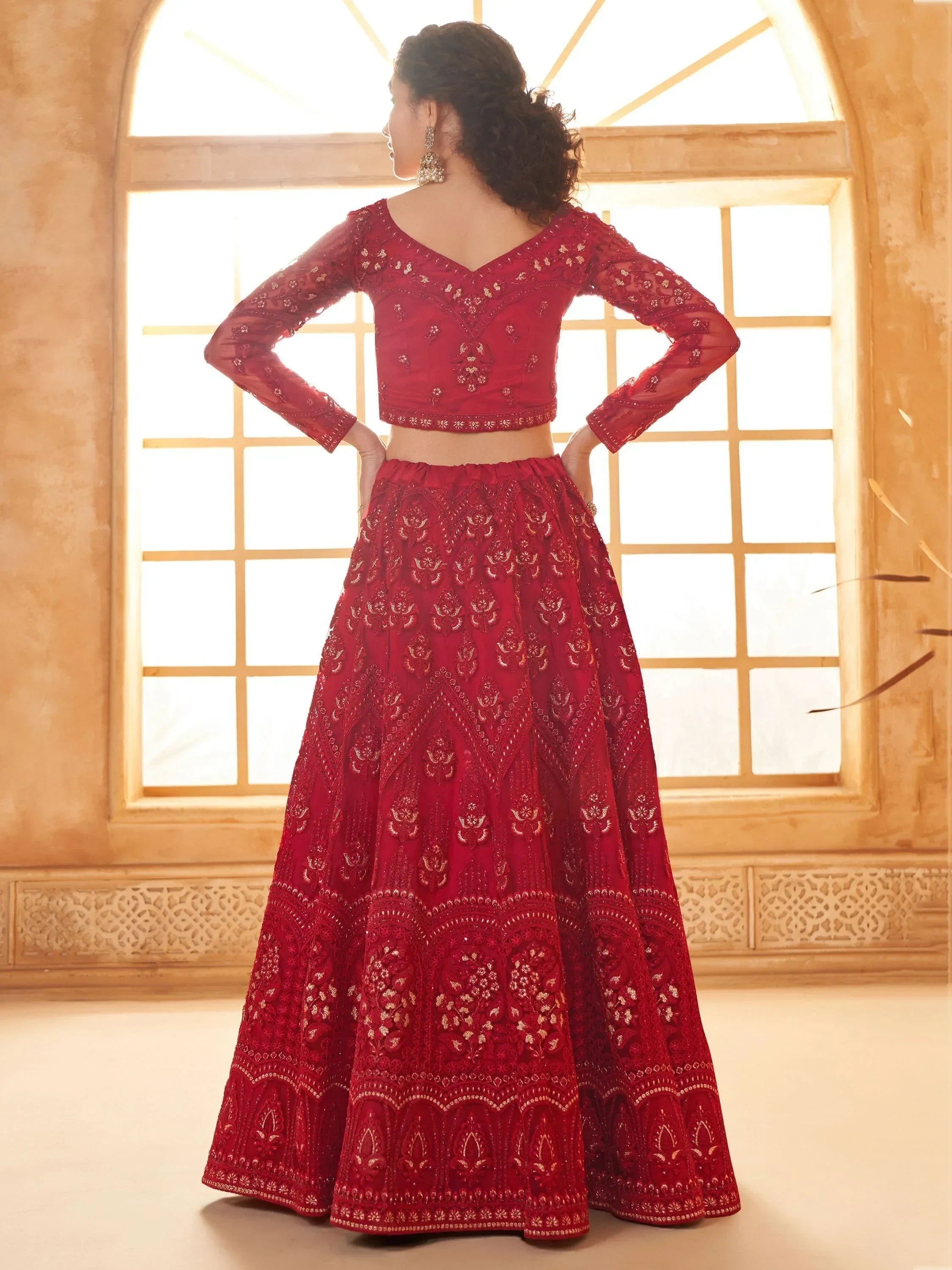 Red embroidered lehenga choli with long sleeves, perfect for Indian weddings and festive occasions.