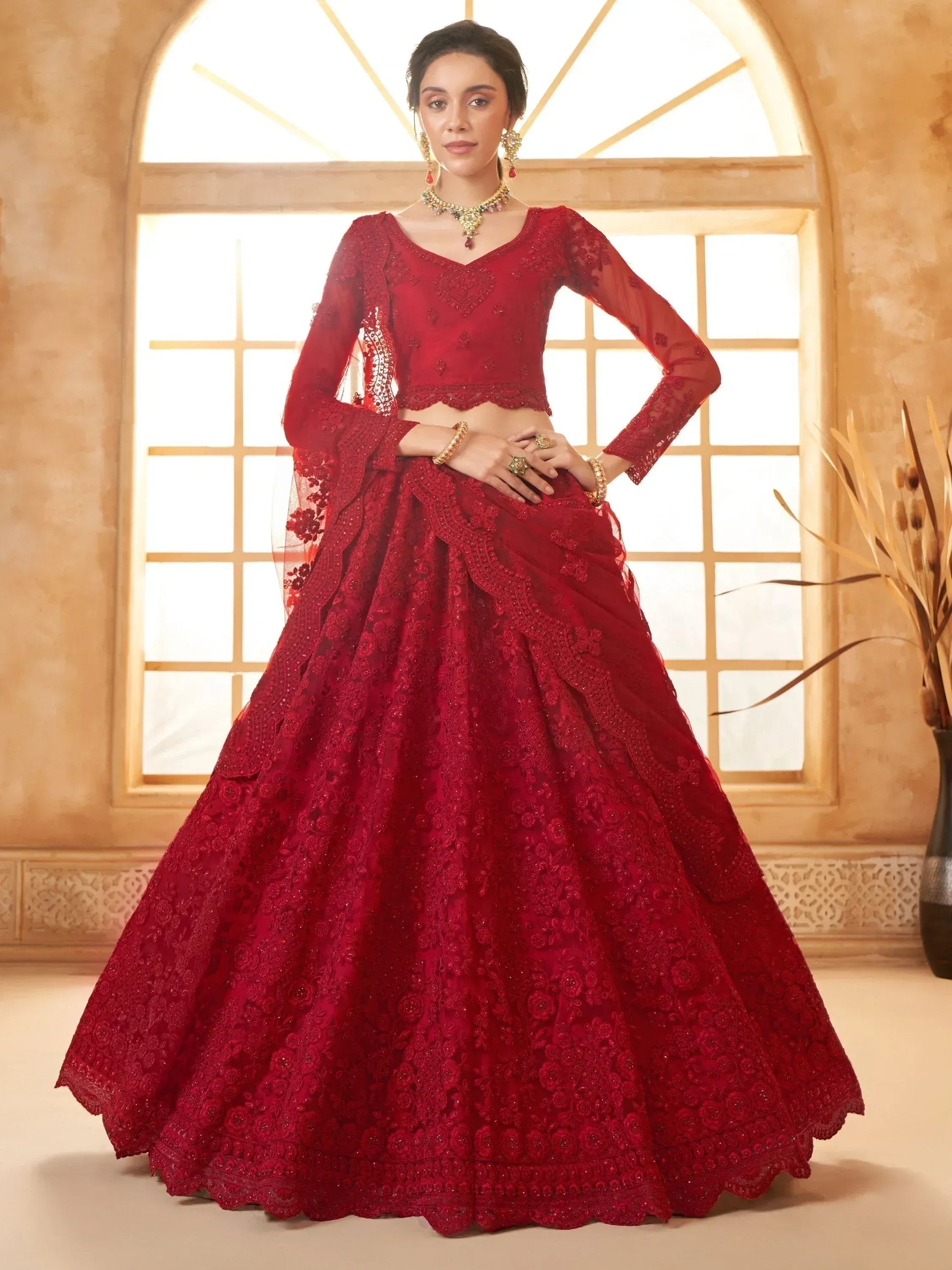 Red embroidered lehenga choli with lace detailing, perfect for Indian weddings and festive occasions