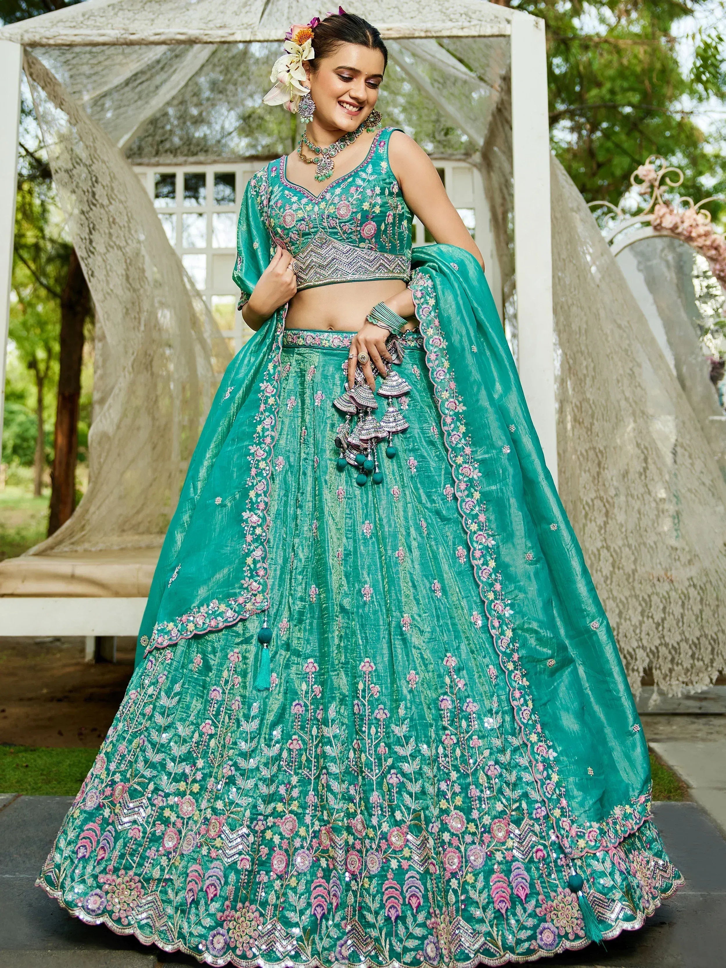 Teal embroidered lehenga choli with floral motifs, perfect for Indian weddings and festive occasions.