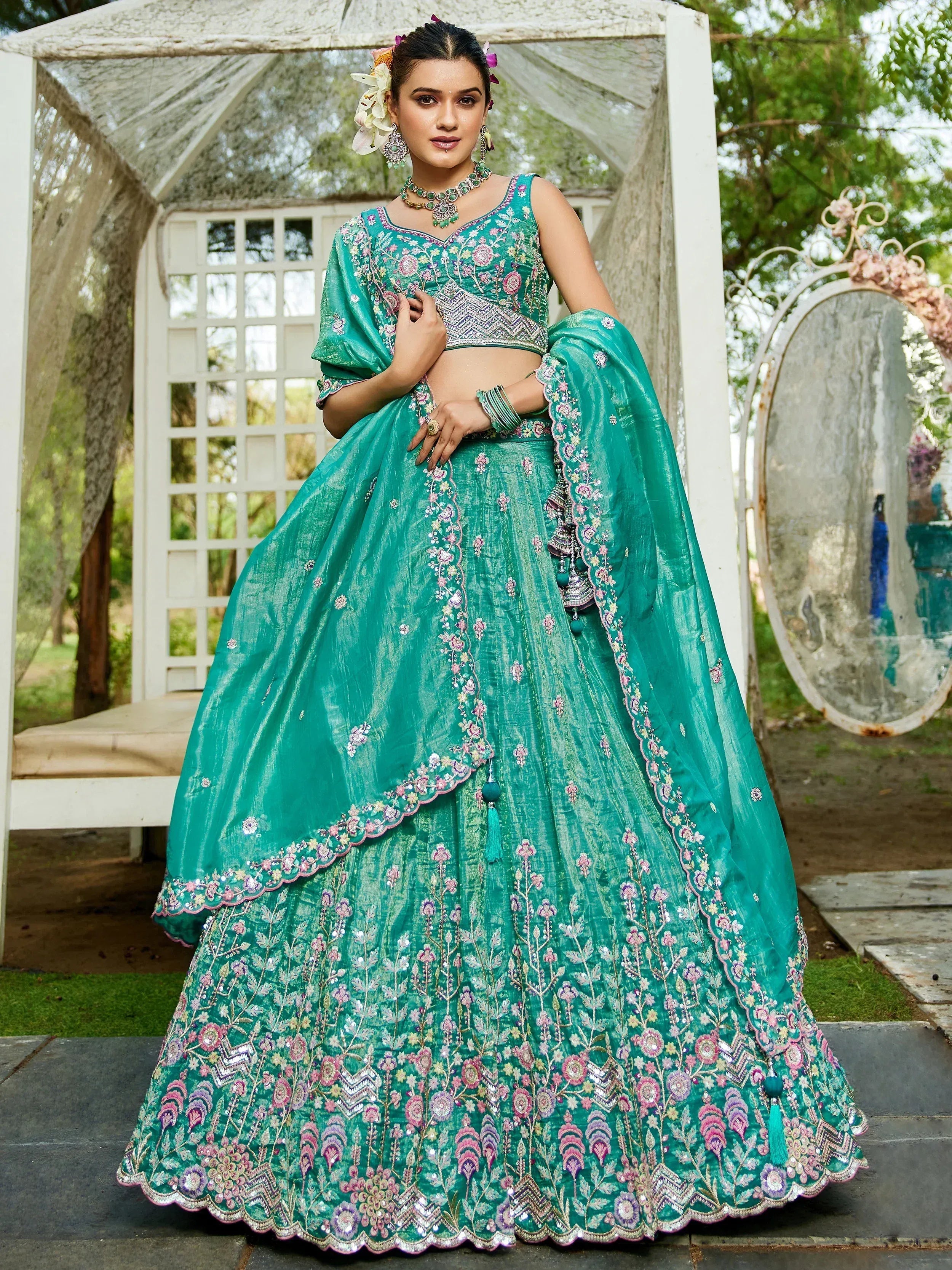 Teal embroidered lehenga choli with floral motifs, perfect for Indian weddings and festive occasions.