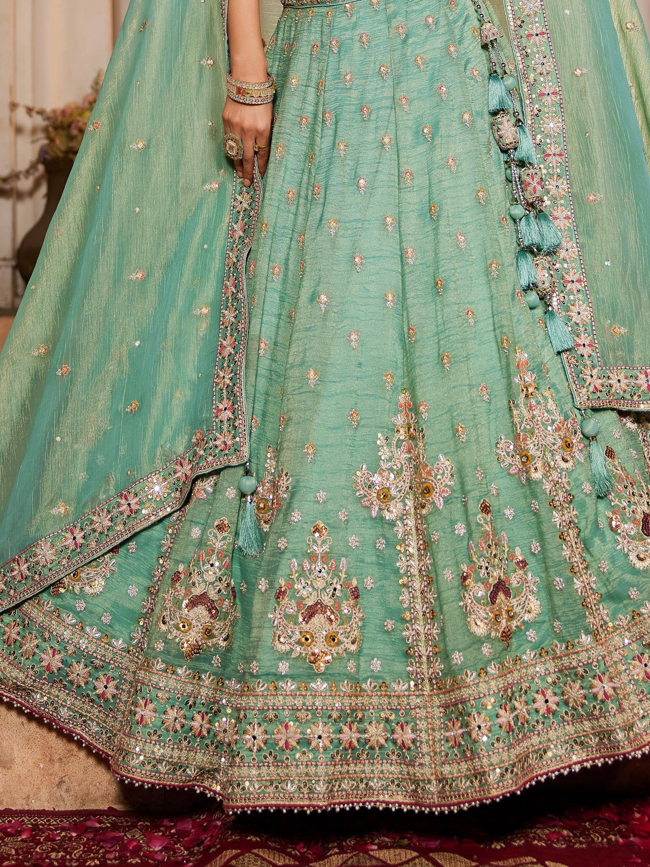 Mint green designer lehenga choli with intricate floral embroidery and tassels, perfect for Indian weddings.