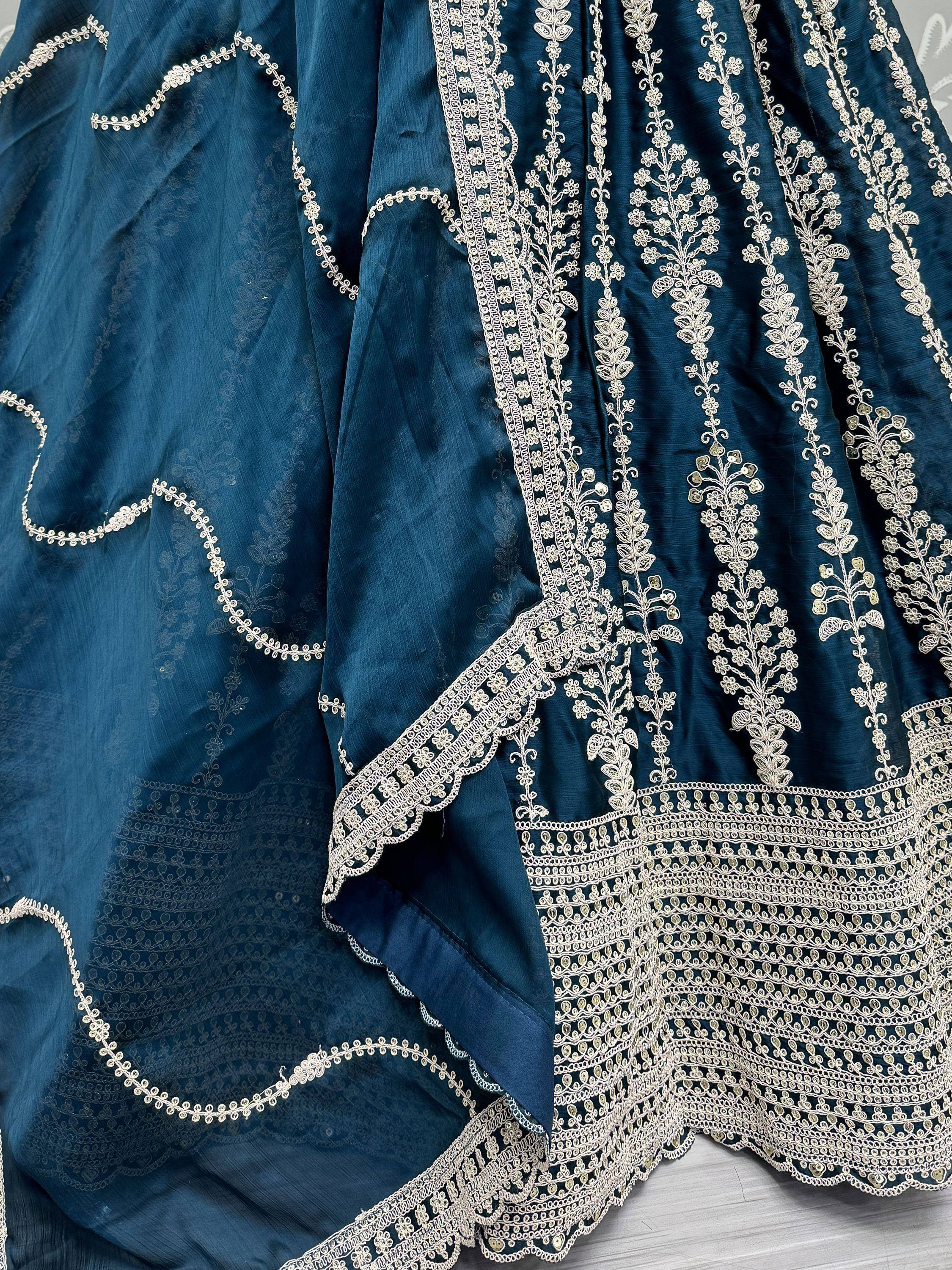 Teal blue ethnic gown with intricate gold floral embroidery and detailed lacework, perfect for Indian occasions.