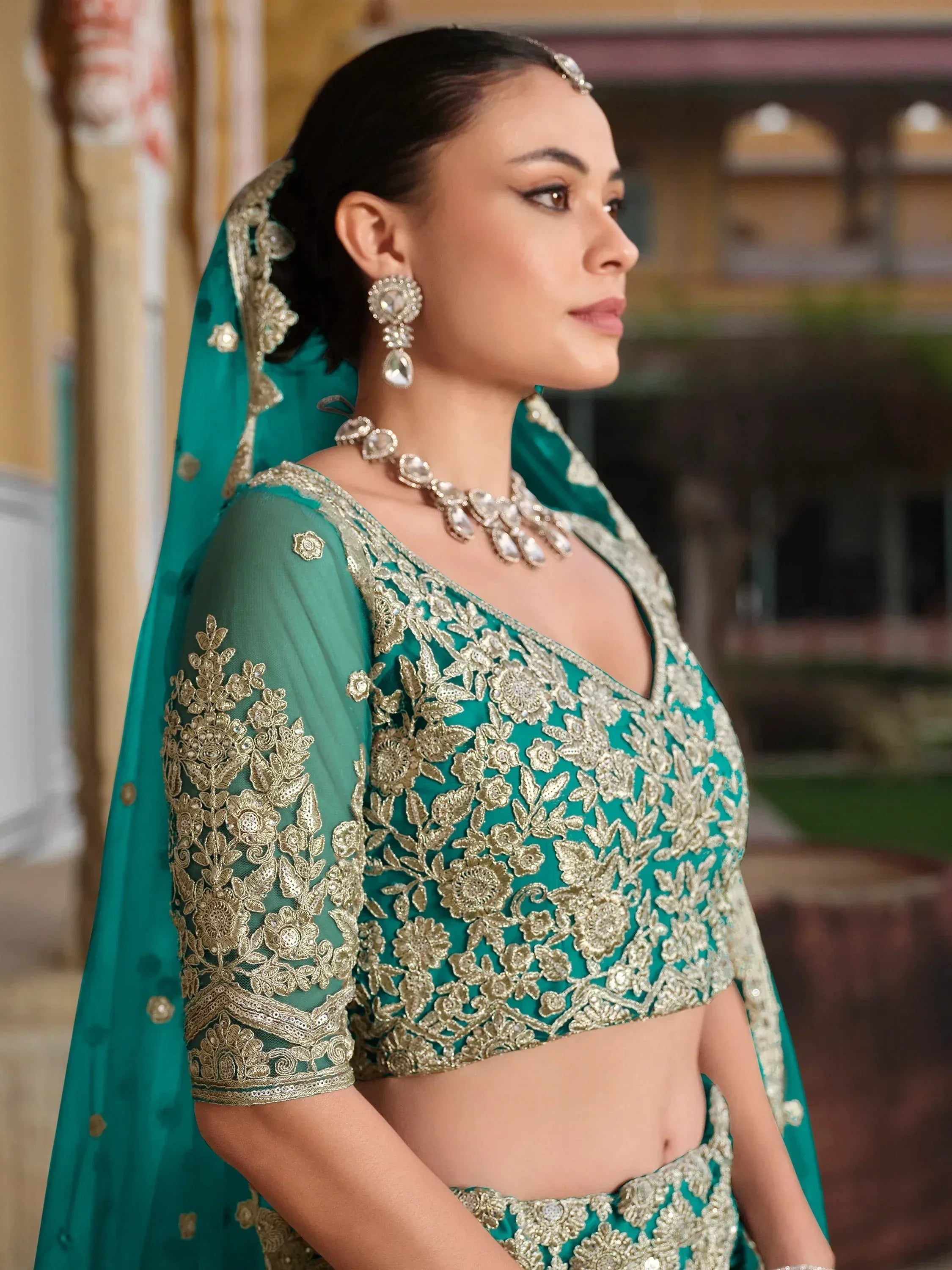 Teal green designer lehenga choli with gold embroidery, perfect for Indian weddings and festive occasions.