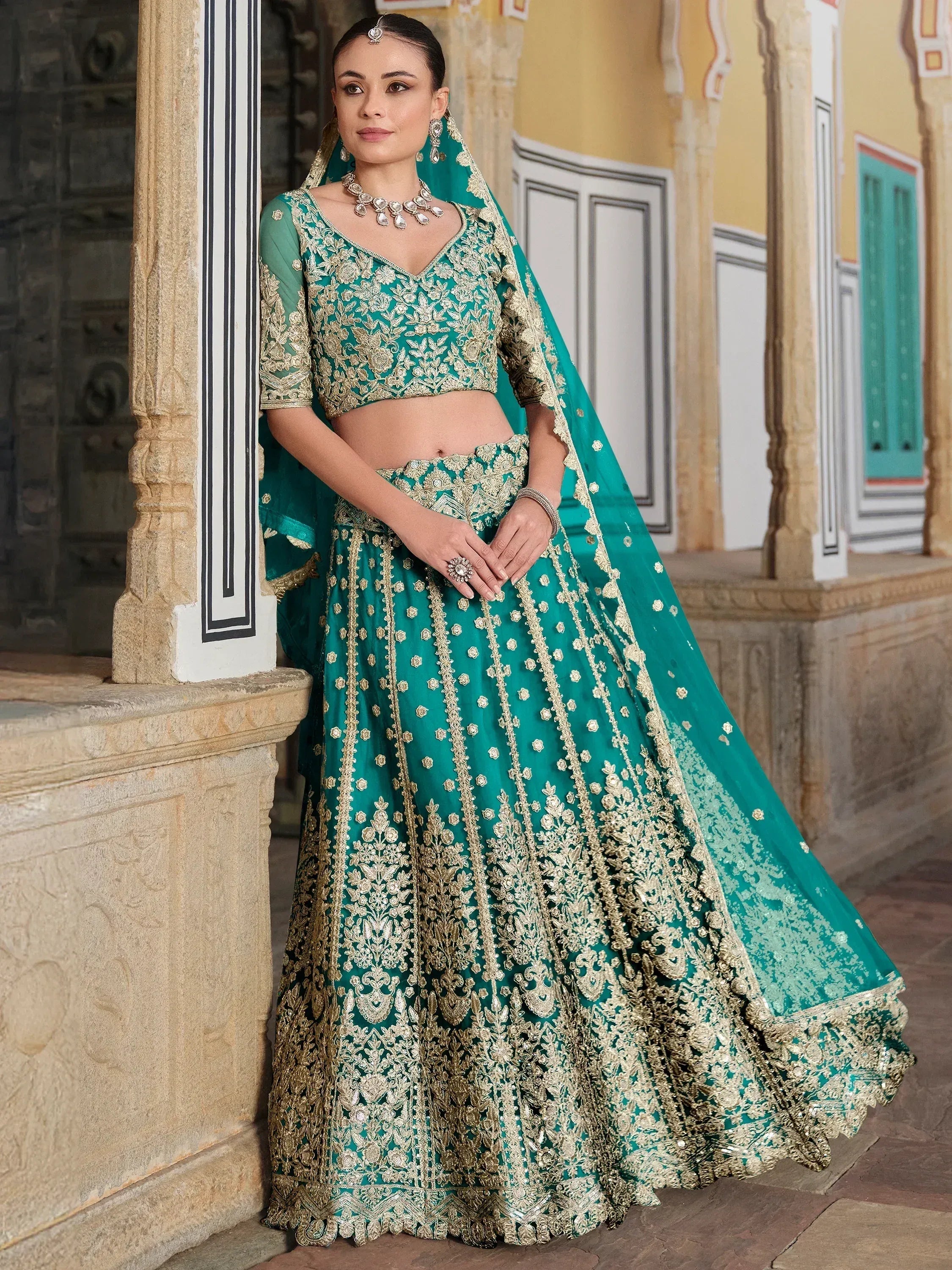 Emerald green designer lehenga choli with gold embroidery, perfect for Indian weddings and festive occasions.