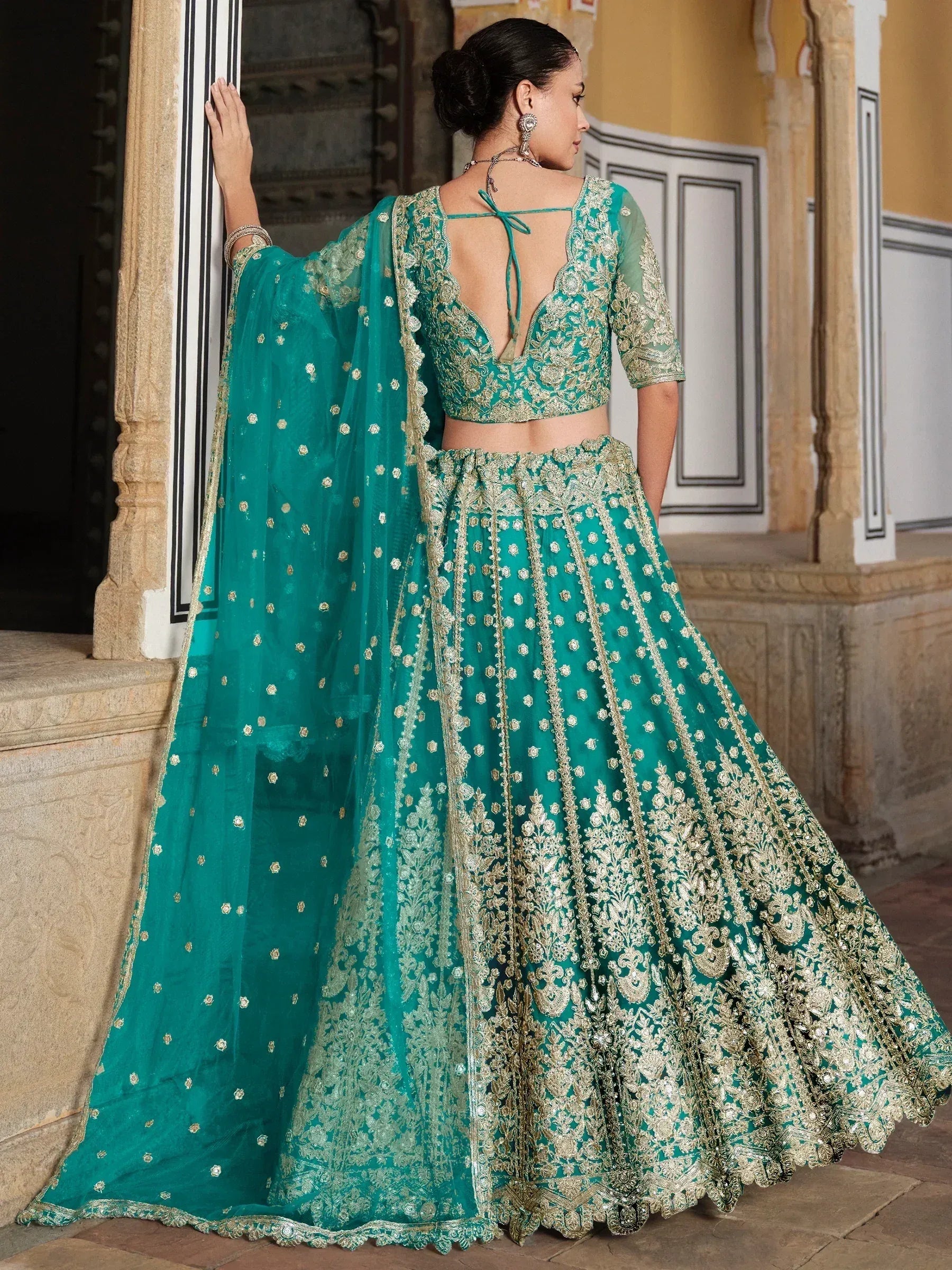 Teal green designer lehenga choli with gold embroidery, back view, ethnic wear for weddings