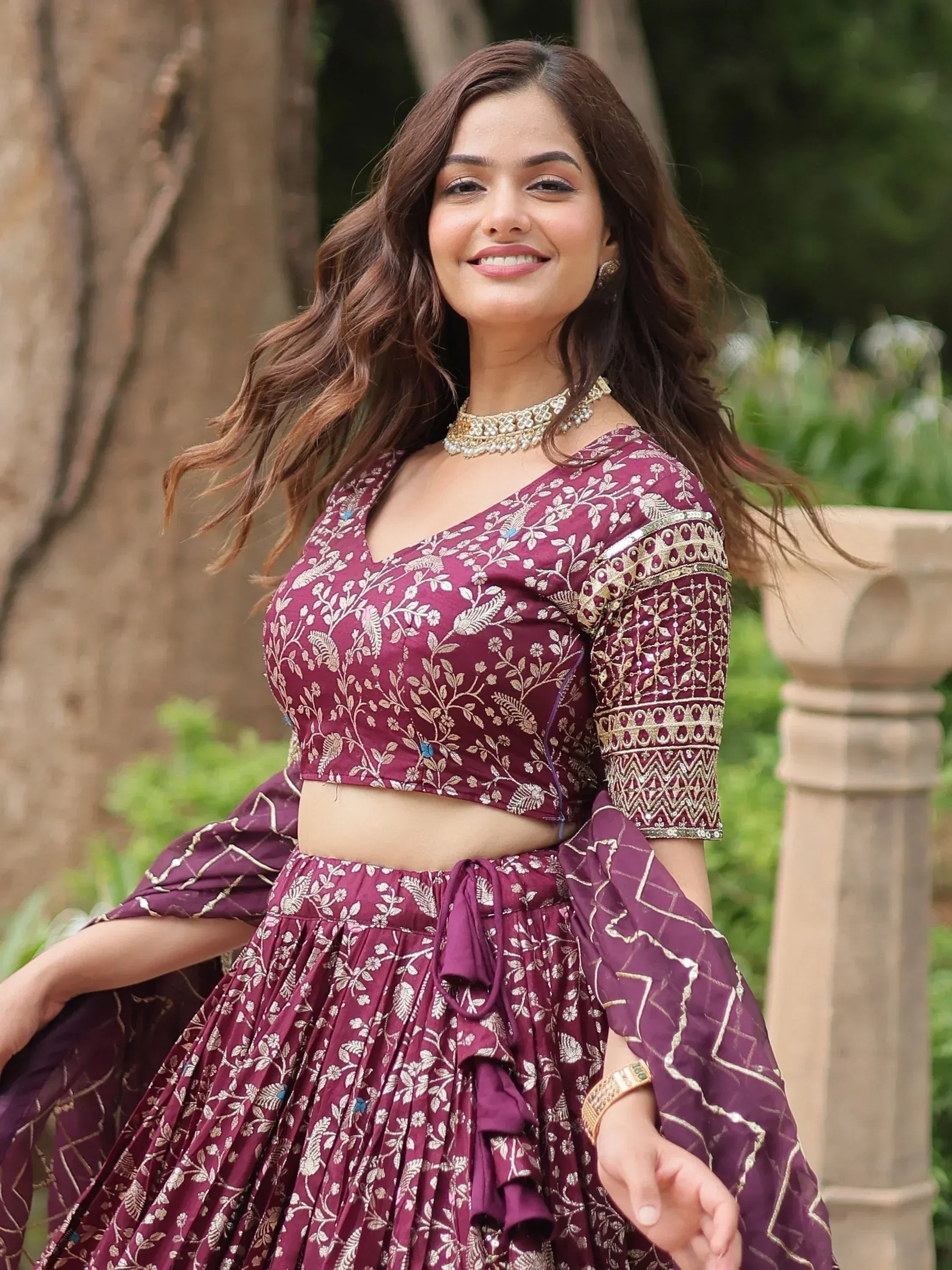 Woman in maroon embroidered lehenga choli with gold floral patterns, perfect for Indian ethnic wear occasions