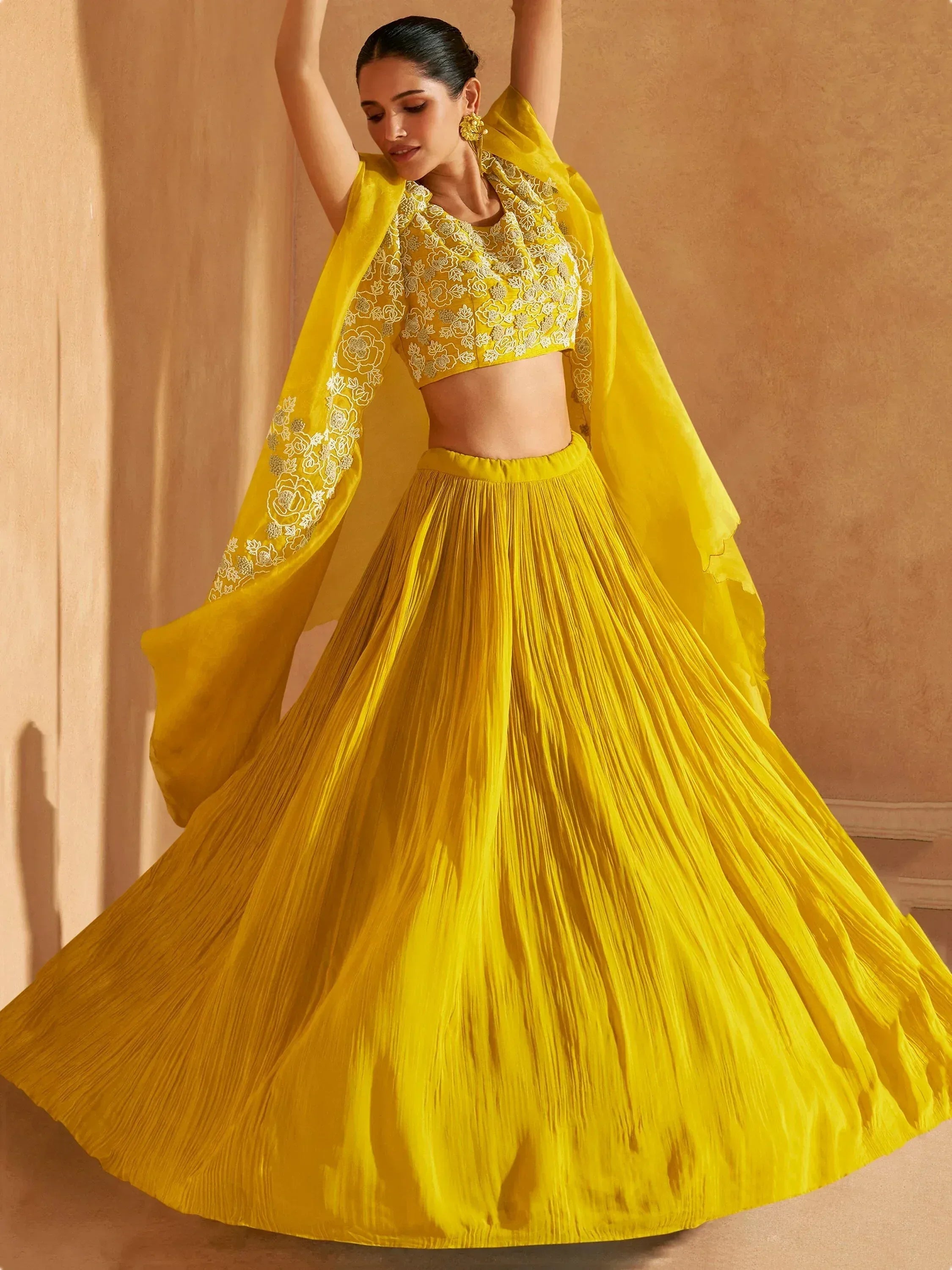 Vibrant yellow embroidered lehenga choli with floral detailing and flowing dupatta, perfect for Indian ethnic occasions.