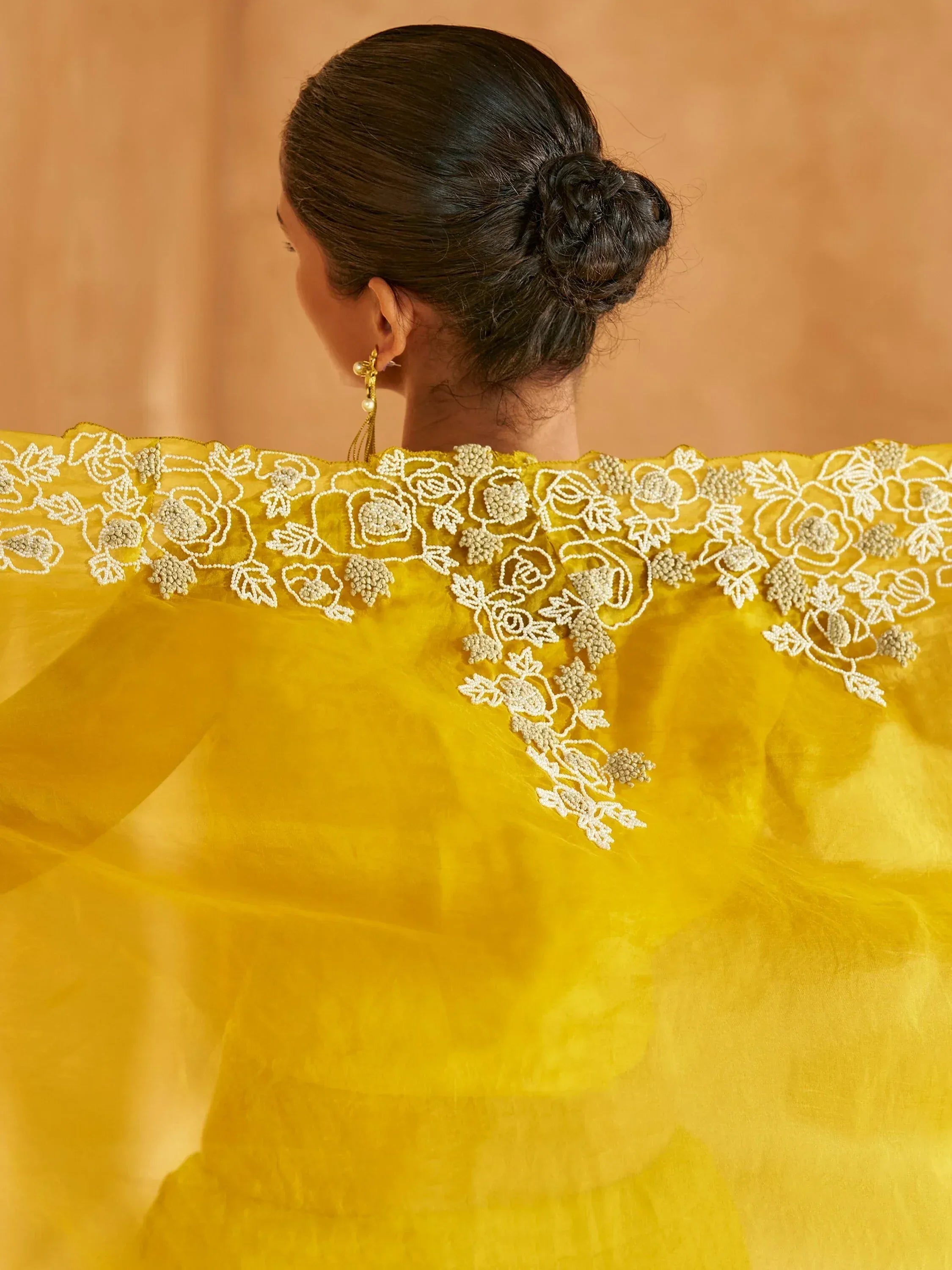 Yellow ethnic gown with white floral embroidery, perfect for Indian weddings or festive occasions.