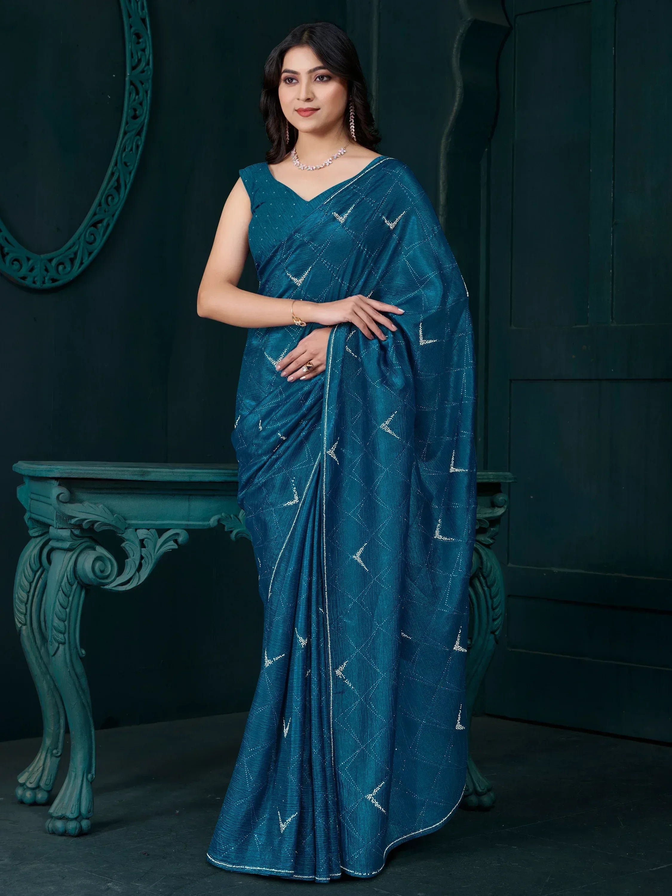 Teal designer saree with silver geometric embroidery, perfect for Indian ethnic wear occasions.