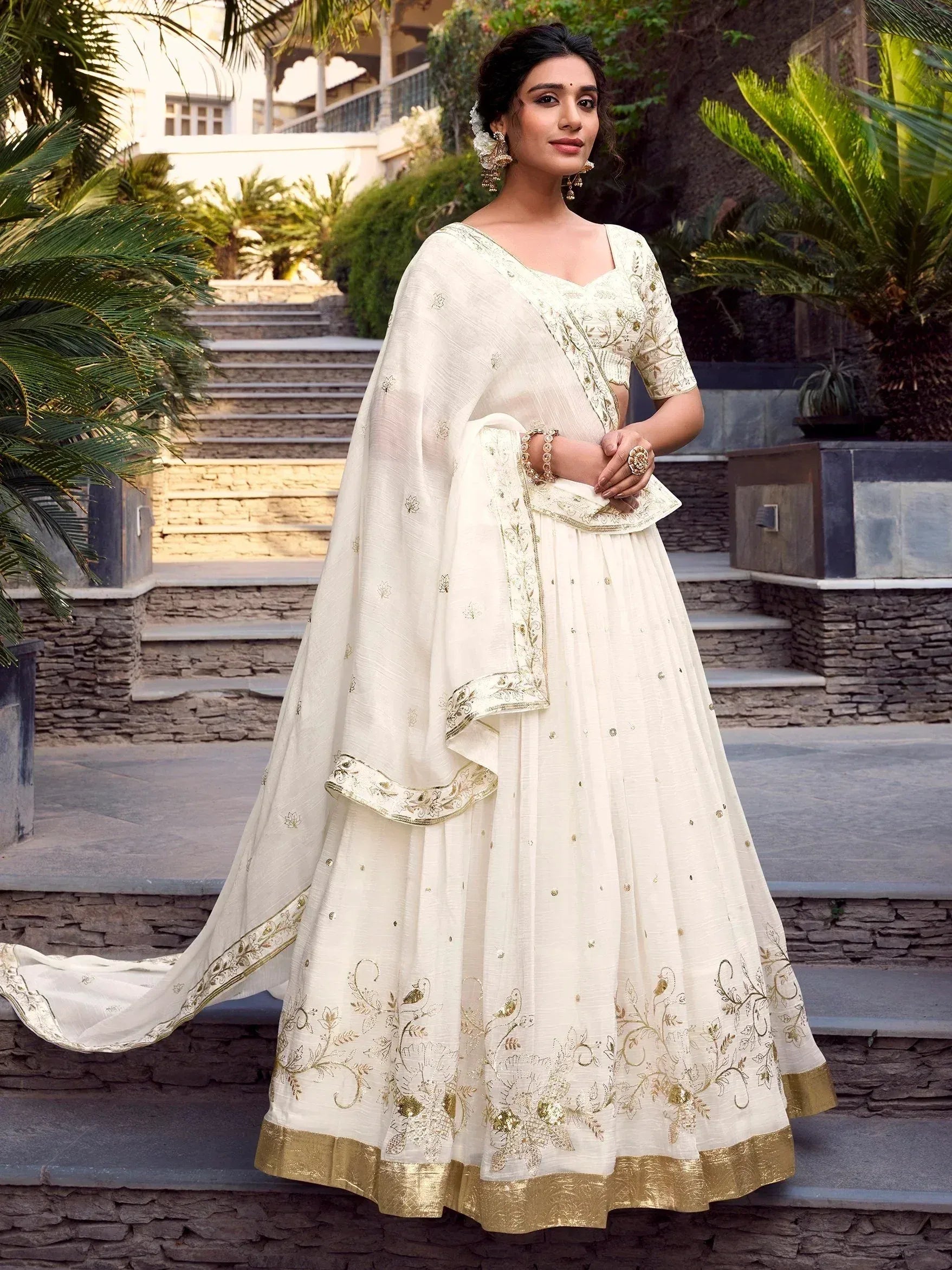 Elegant ivory lehenga choli with gold embroidery, perfect for Indian weddings and festive occasions.