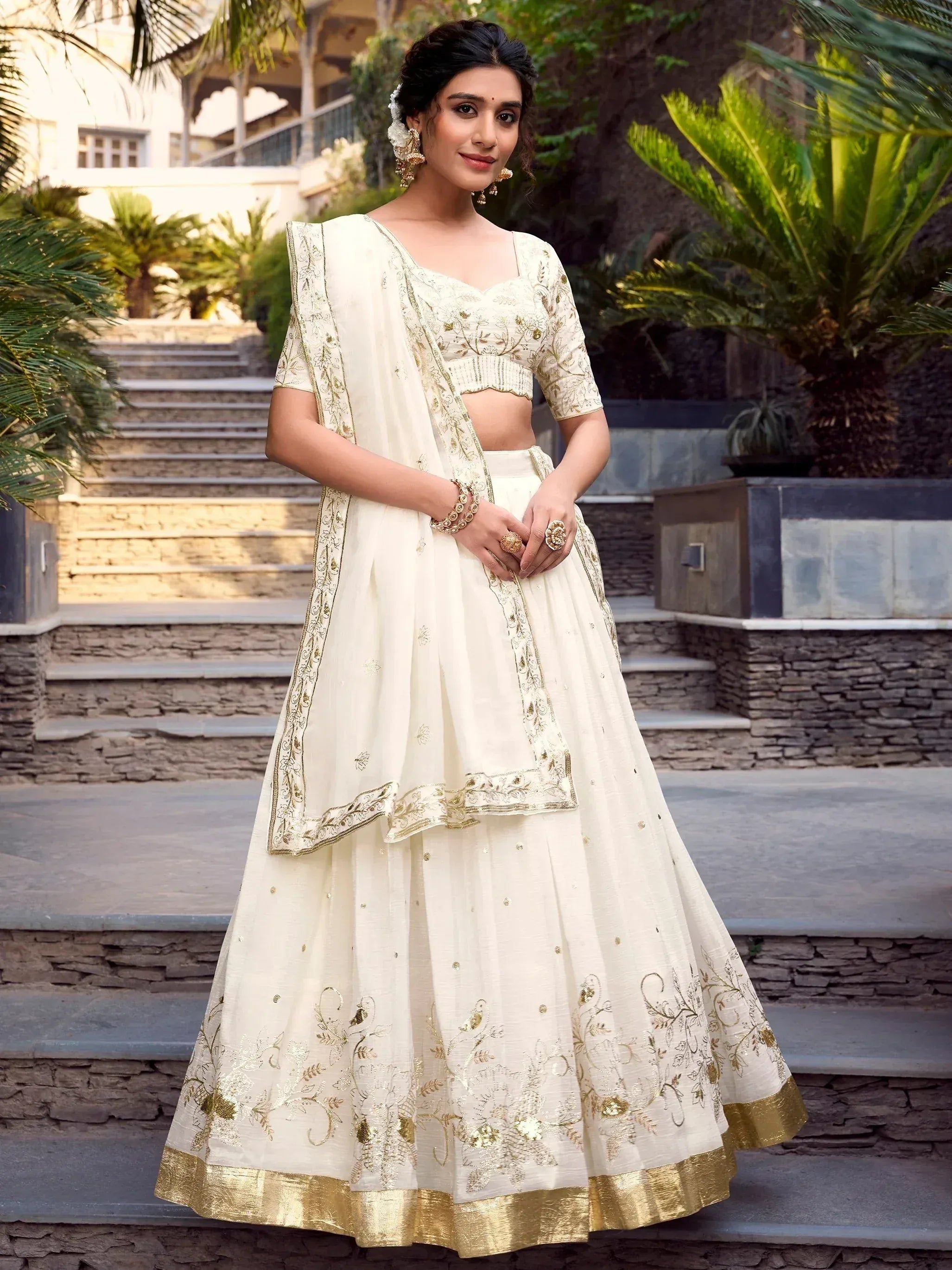 Elegant ivory lehenga choli with gold embroidery, perfect for Indian weddings and festive occasions.