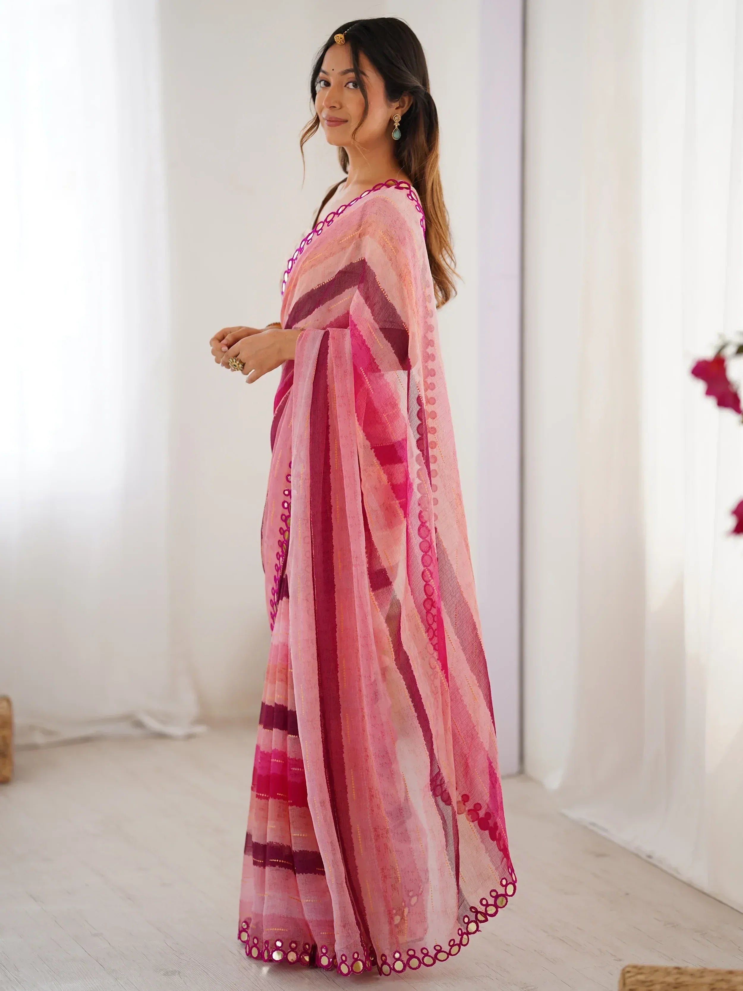 Pink and magenta striped saree with mirror work border, styled with ethnic jewelry for Indian occasions
