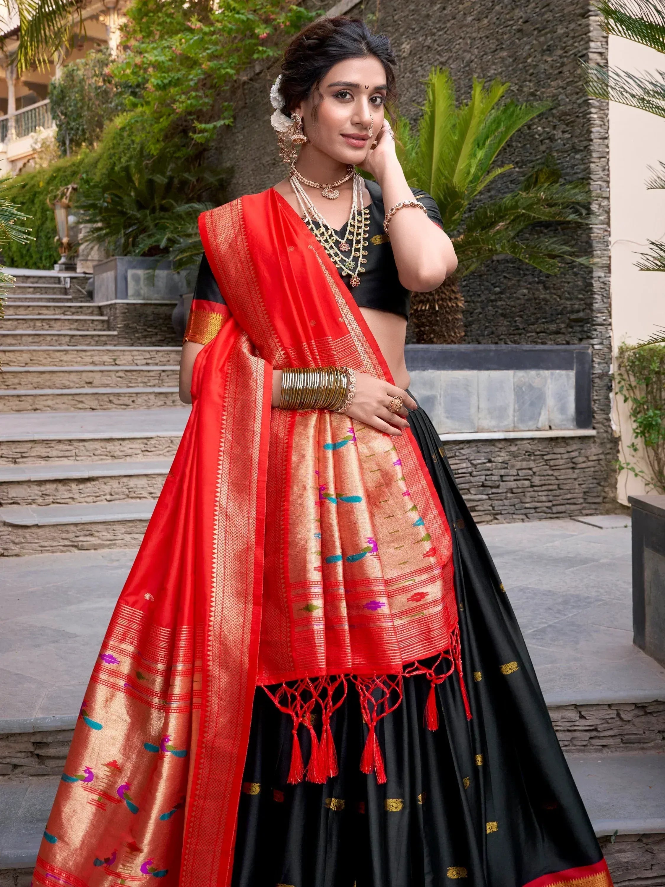 Woman in black and red designer lehenga choli with peacock motifs, perfect for Indian ethnic wear occasions