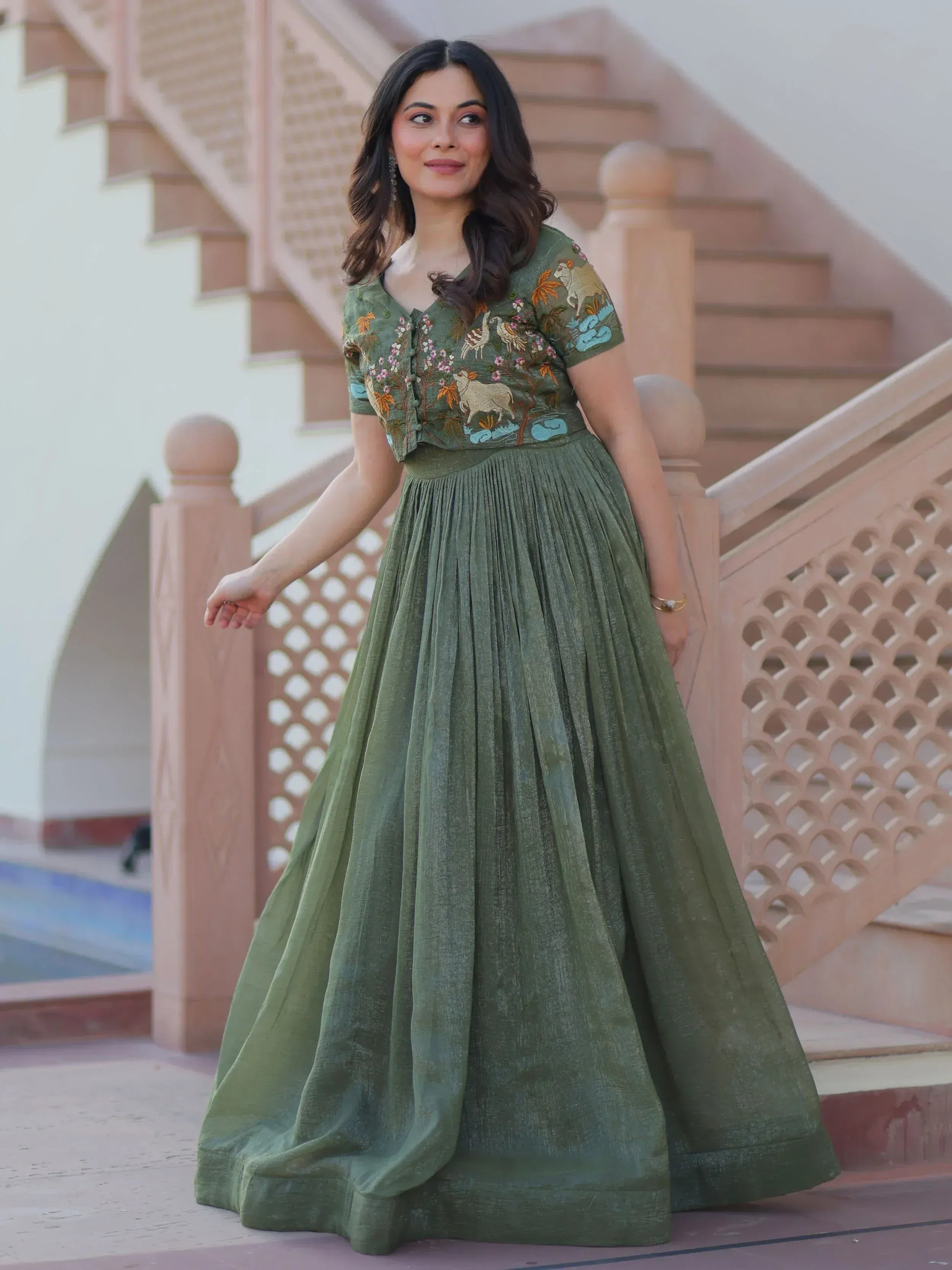 Olive green embroidered ethnic gown with floral and animal motifs, pleated skirt, perfect for Indian occasions