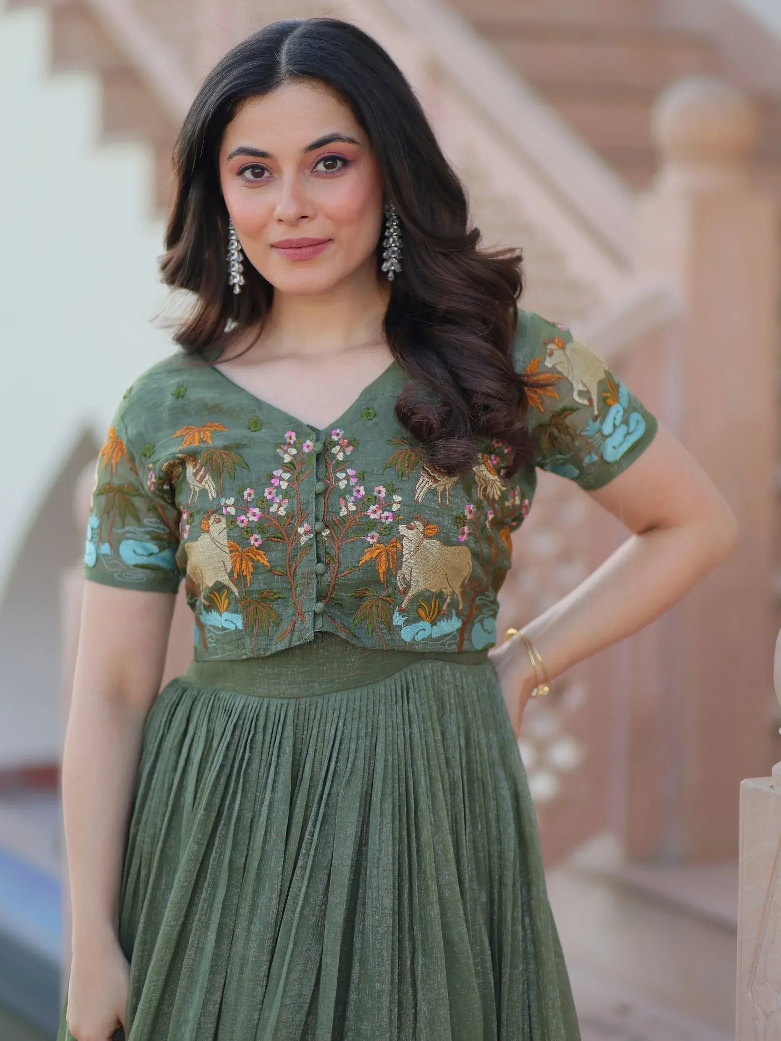Green embroidered ethnic gown with floral and animal motifs, perfect for Indian occasions