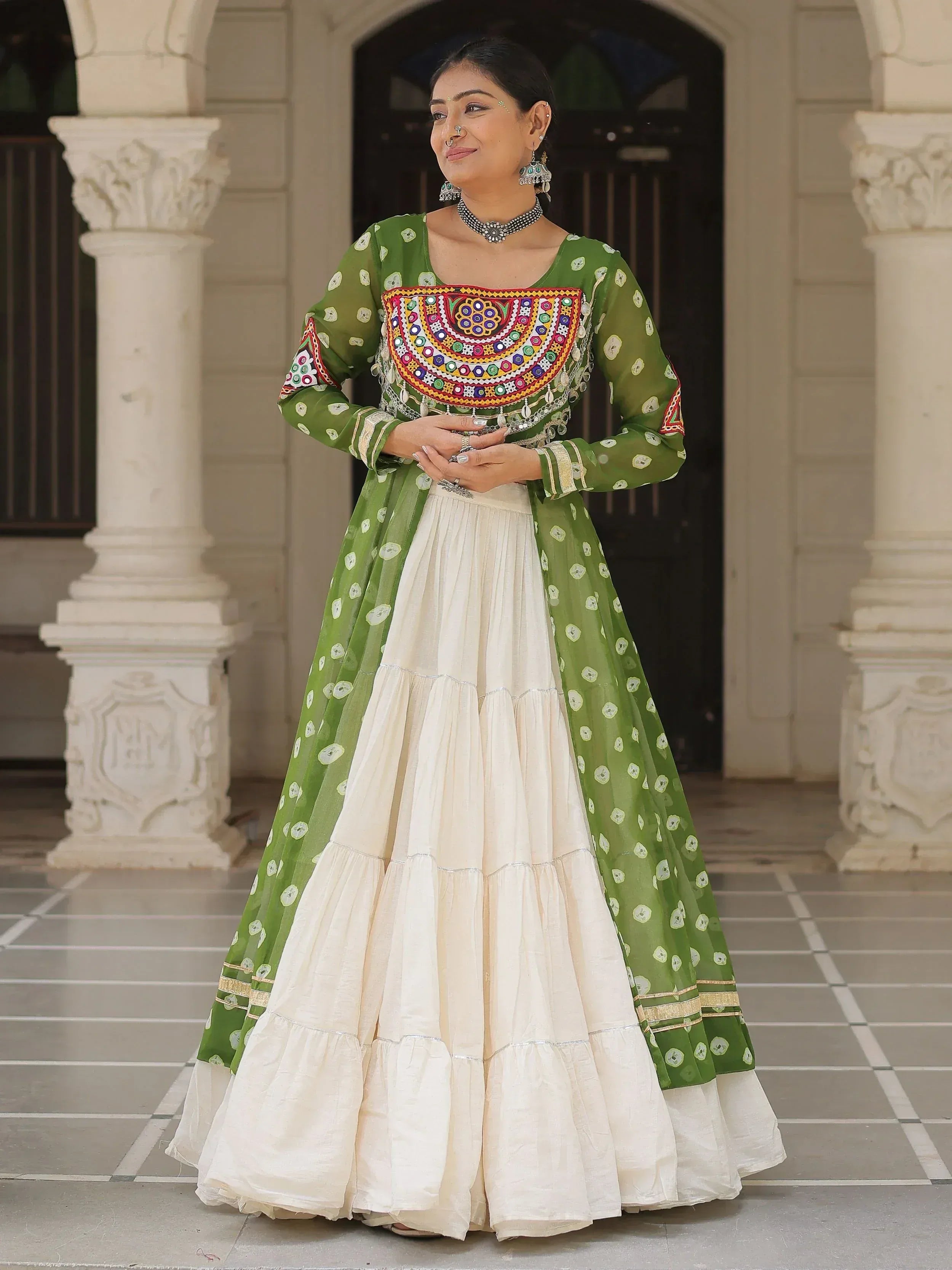 Green and cream ethnic Anarkali suit with mirror work and tiered skirt, perfect for Indian celebrations