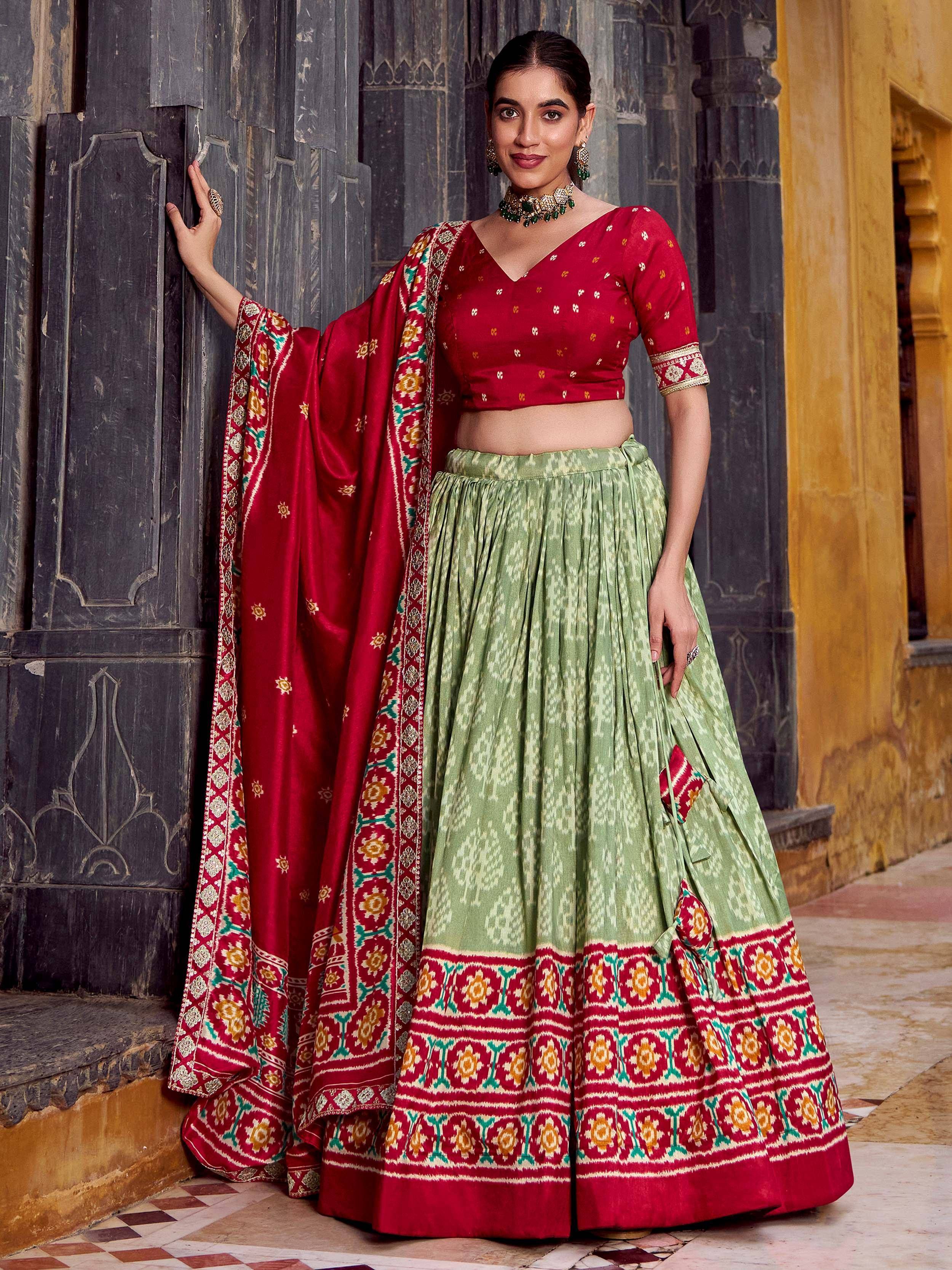 Red and green ethnic lehenga choli with intricate embroidery, perfect for Indian weddings and festive occasions.