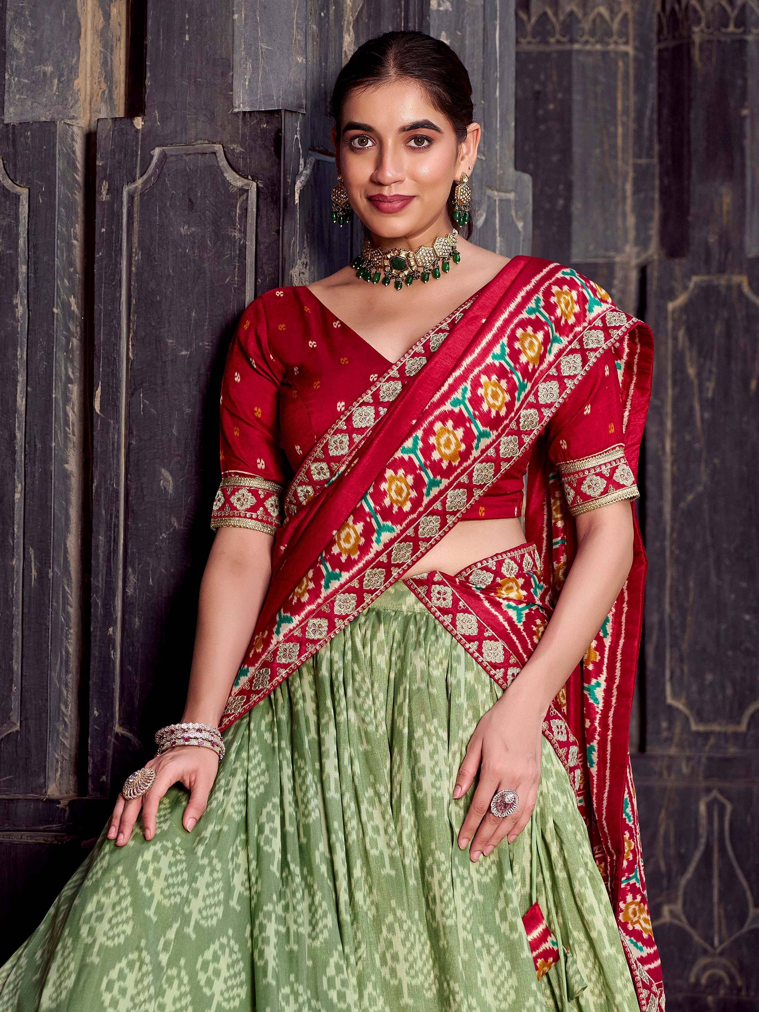 Woman in red and green Ikat lehenga choli with gold embroidery, traditional Indian ethnic wear