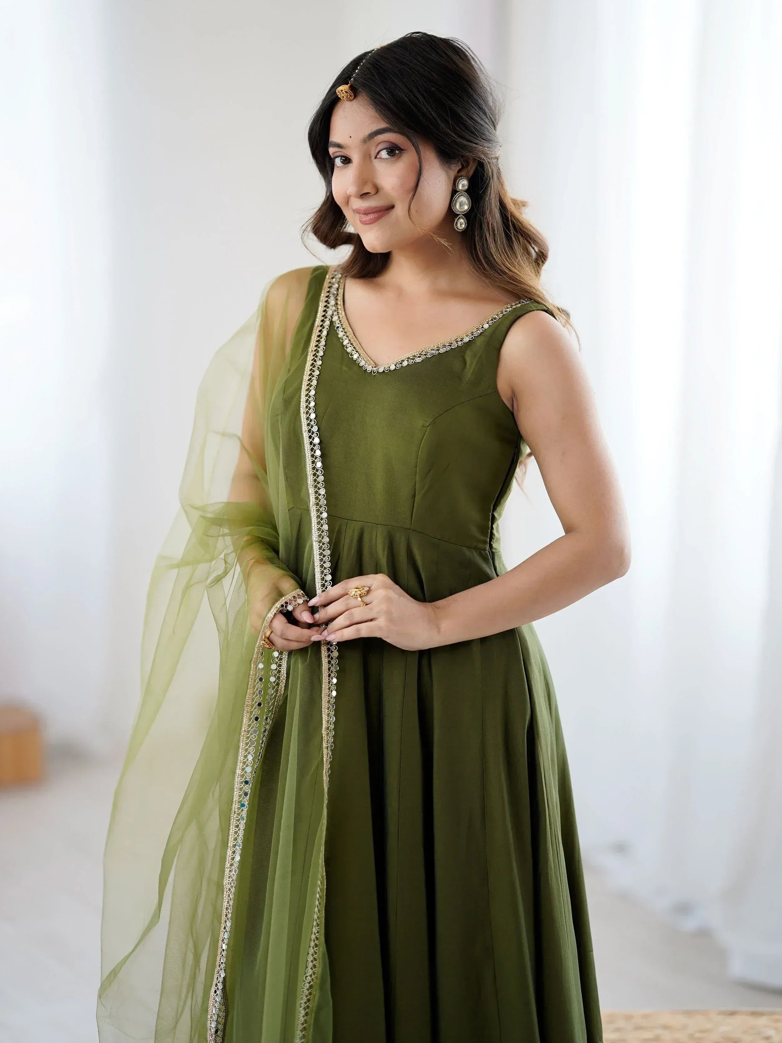 Olive green ethnic gown with gold embroidery and sheer dupatta, perfect for Indian occasions