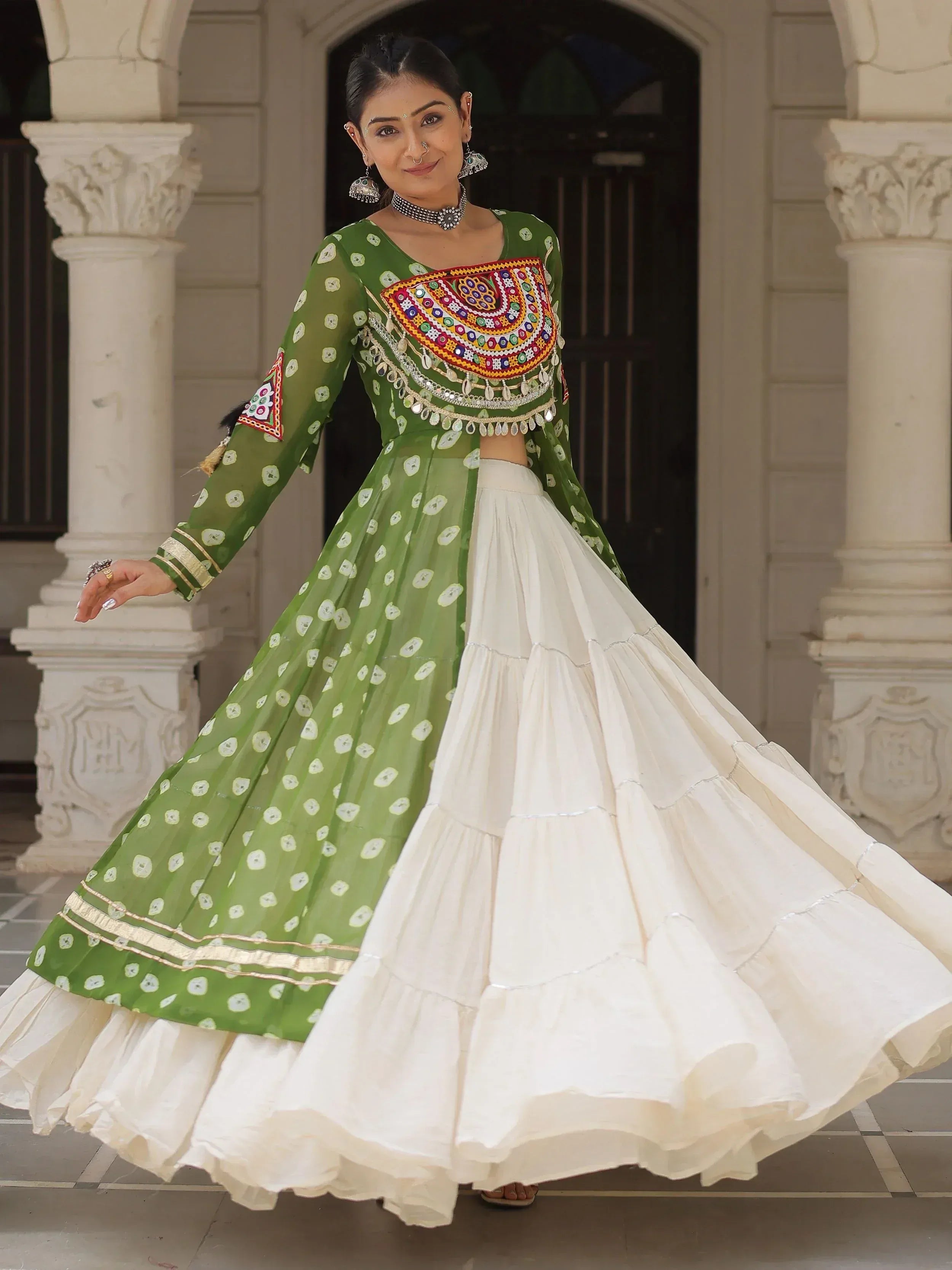 Green and white embroidered lehenga choli with mirror work, perfect for Indian ethnic wear events.