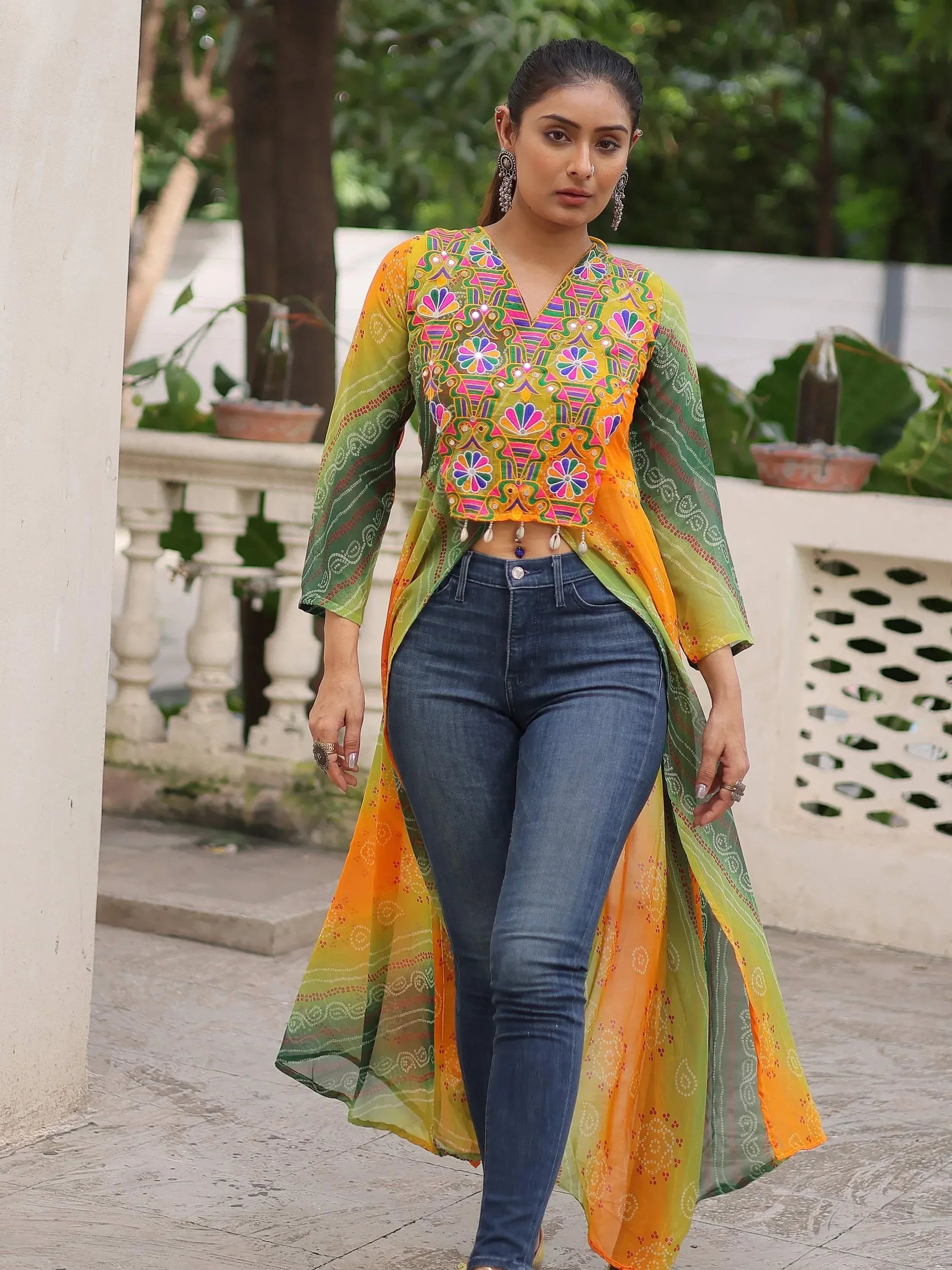 Colorful embroidered ethnic crop top with sheer ombre jacket paired with jeans, perfect for fusion wear.